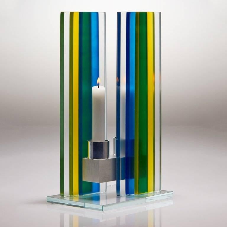 This polished glass, double candleholder is designed by world renowned glass artist, Sidney Hutter. With 40 years of experience in the contemporary glass and Fine Art world, Sidney now creates illuminated designs for the home. Create a centerpiece