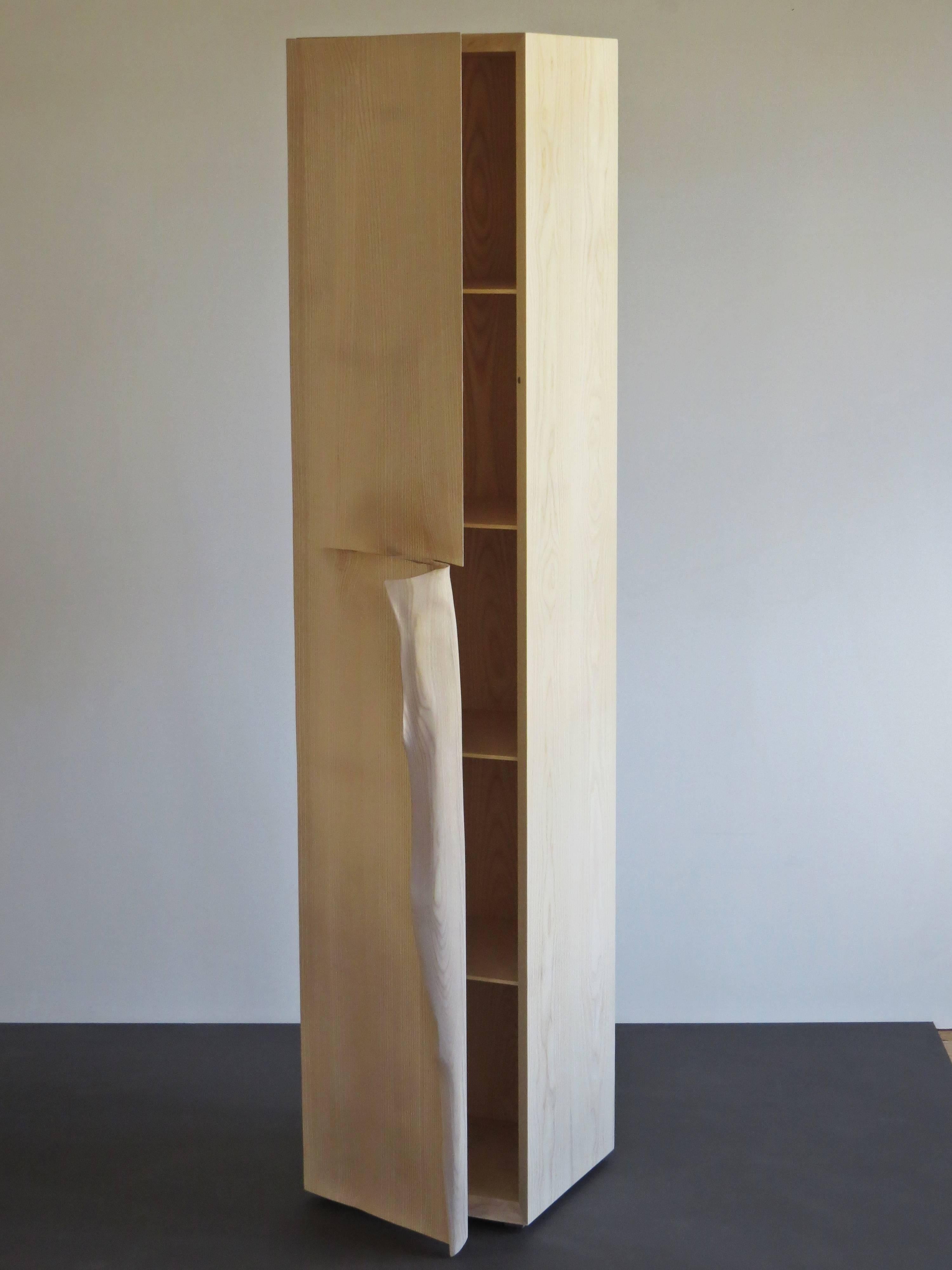 Hochschrank handgefertigt aus massivem Eschenholz.
Entworfen von dem deutschen Möbelhersteller und Bildhauer Eckehard Weimann.
Ein klassischer geradliniger Körper wird durch einen Griff wie ein Eselsohr durchbrochen.
Geformt sieht dieser Griff