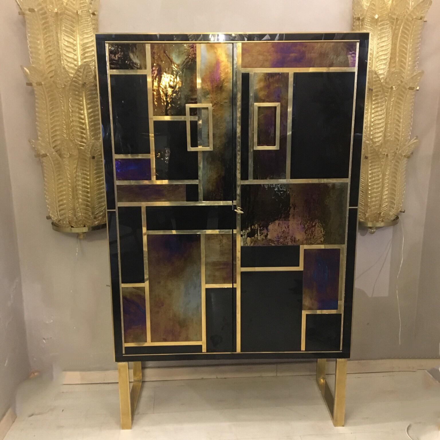 Pair of Italian opaline glass cabinets brass fittings, black and iridescent gold opaline glass, one shelve inside. Top and sides in black opaline glass. When the light reflects on the cabinet, the color of the gold opalines changes creating