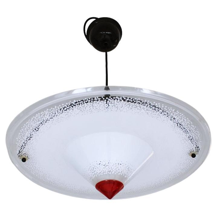 Stunning vintage UFO shaped 1980s pendant light. It's a well made large ceiling lamp. White acrylic disc and black lacquered parts that goes with it.
In very good vintage condition with small signs of age.
Manufactured in West Germany
It uses