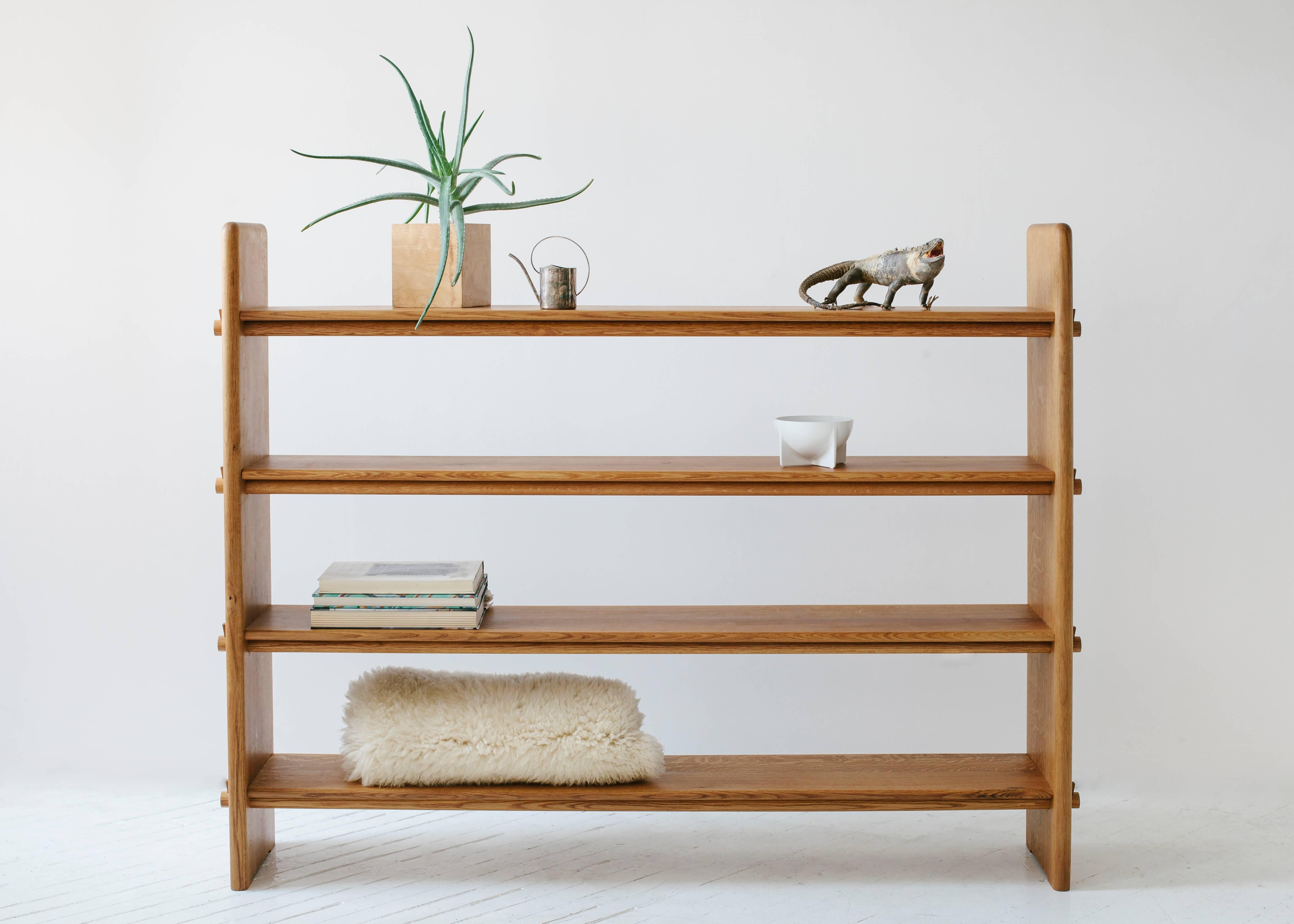 Designed with a focus on traditional joinery, there is not a single piece of metal hardware used in these white oakwood shelves. Small wooden wedges are used to hold the shelves captive between the vertical sides through sheer tension.