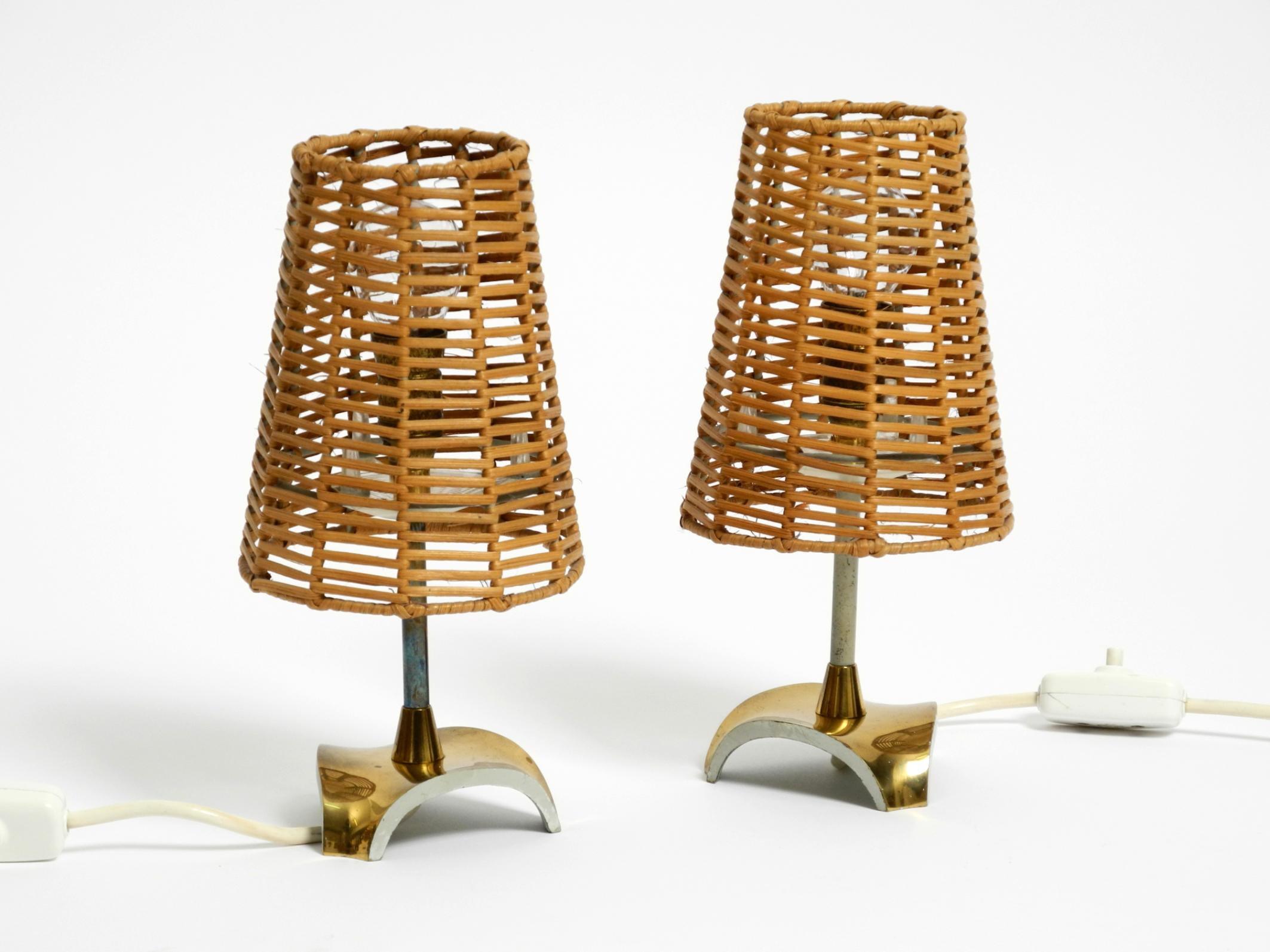 Une paire de lampes de table en laiton avec abat-jour en rotin.
Design typique des années 1950. Très bon état vintage, sans dommage pour le cadre ou l'abat-jour. Le tressage du rotin est impeccable.
Les fixations en plastique de l'abat-jour sont