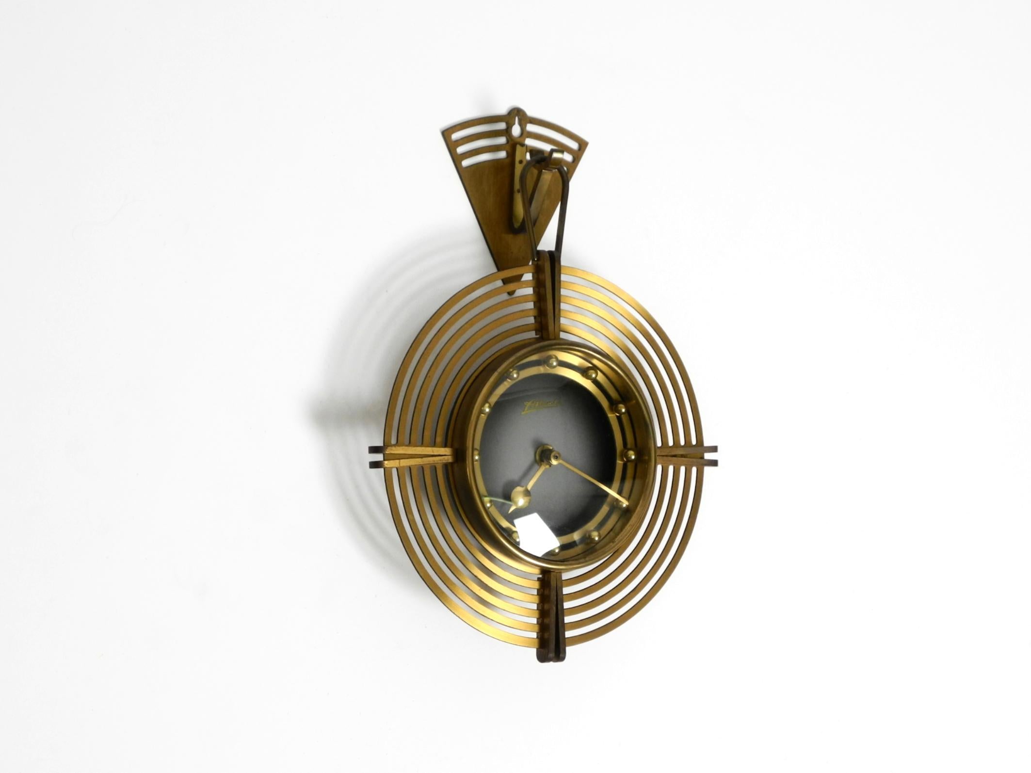 Beautiful, original, unique, round Mid-Century Modern Atlanta wall clock. Made in Germany.
Very beautiful, elaborate Mid-Century design. Made entirely of brass.
The hook is screwed to the wall, and the clock is hung at it.
Battery-operated with an