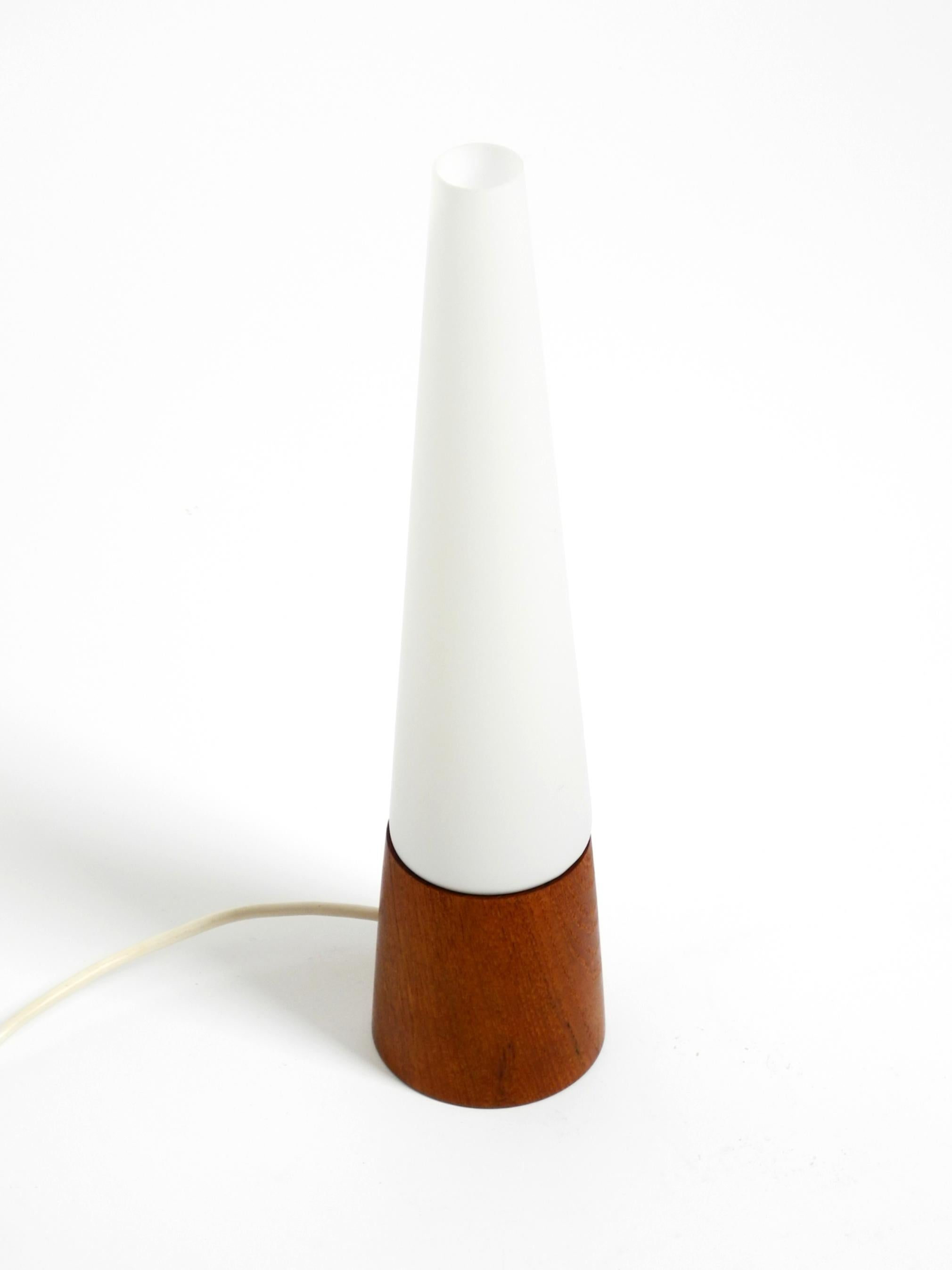 Belle lampe de table en teck des années 1960 avec un abat-jour conique en verre.
Conçu par Hans Agne Jakobsson pour Markaryd. Fabriqué en Suède.
Il s'agit d'un original, mais le Label est manquant, il est tombé à un moment donné.
Un beau classique