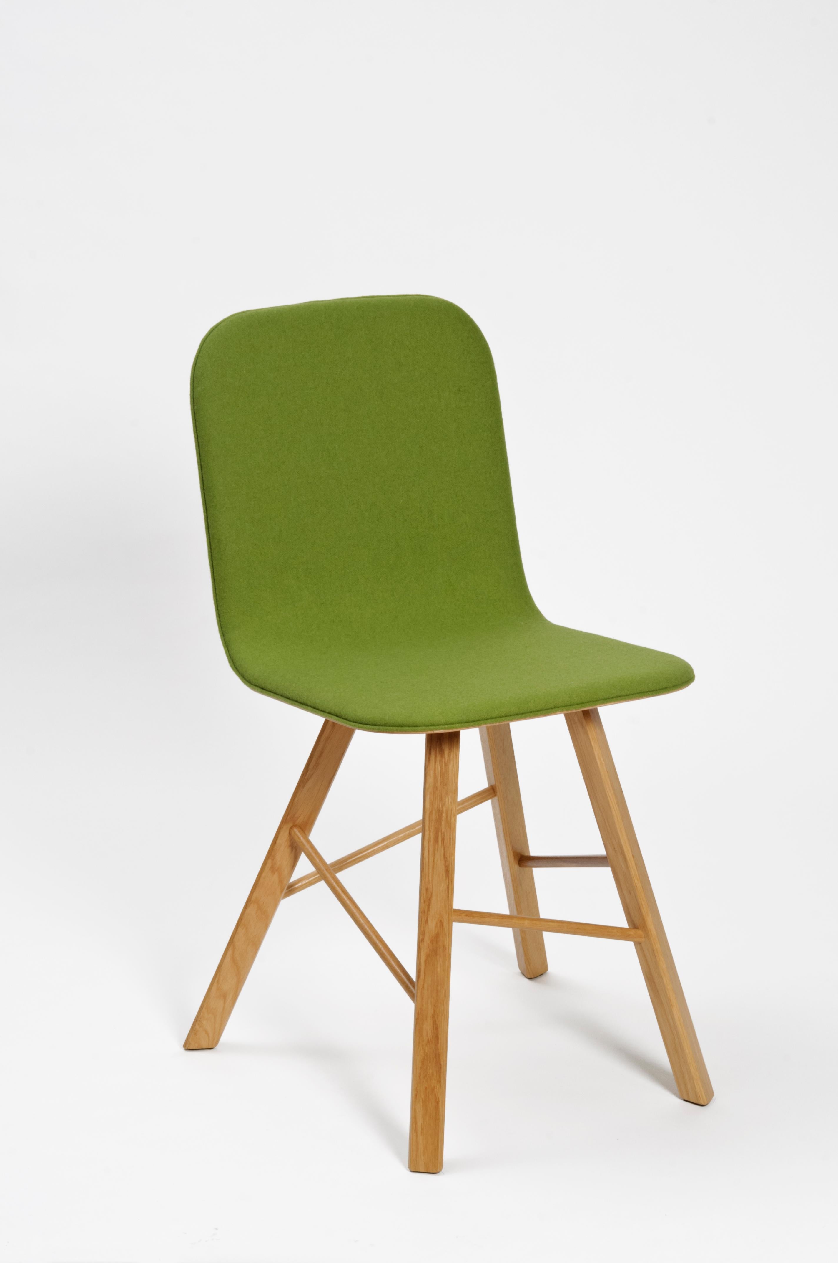 Sedia essenziale ed elegante con scocca in compensato curvato e quattro iconiche gambe a forma triangolare in rovere massiccio, unite da barre di legno trasversali.
Il ripiano è rivestito in feltro arancione disponibile in diversi colori. Fodera in