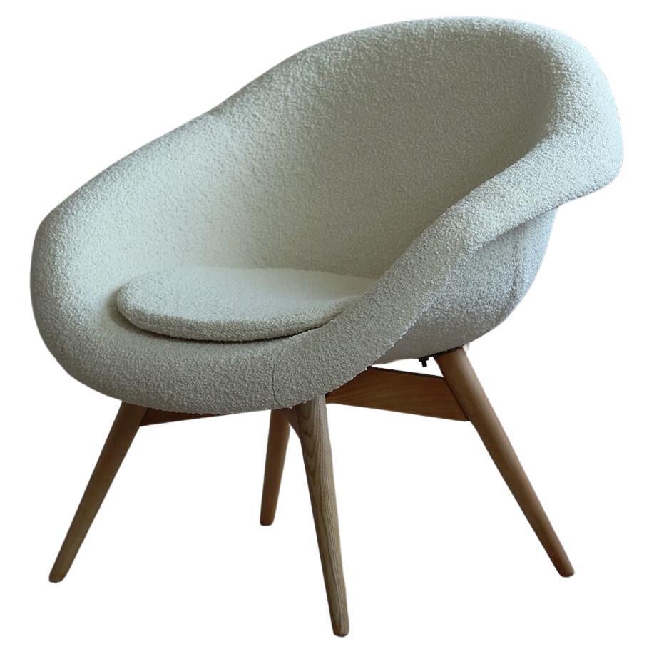 This set of 2 lounge chairs was designed in 1950s by Miroslav Navrátil in Czech Republic. They feature fiberglass seating shell and wooden base. They have been renovated and reupholstered with French boucle fabric from Bisson Bruneel brand that gave