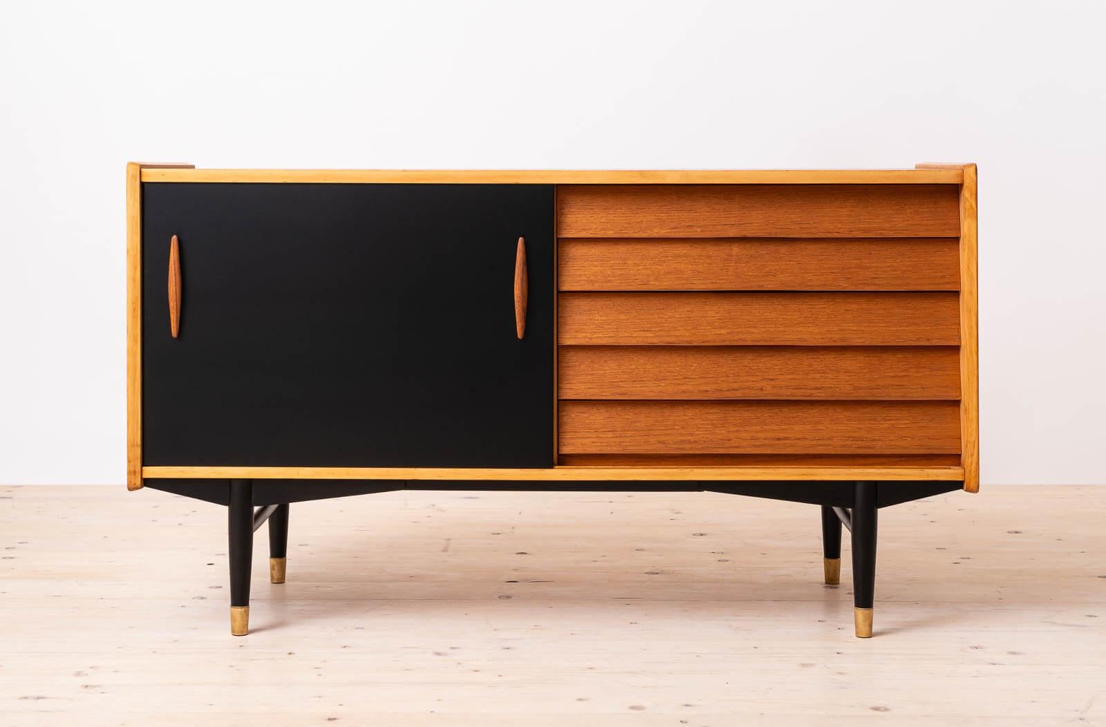 Discover the rare elegance of this distinctive teak wood sideboard, a unique design by Nils Jonsson exemplifying the timeless allure of Scandinavian Modern style. Crafted with precision and attention to detail, this remarkable piece features black