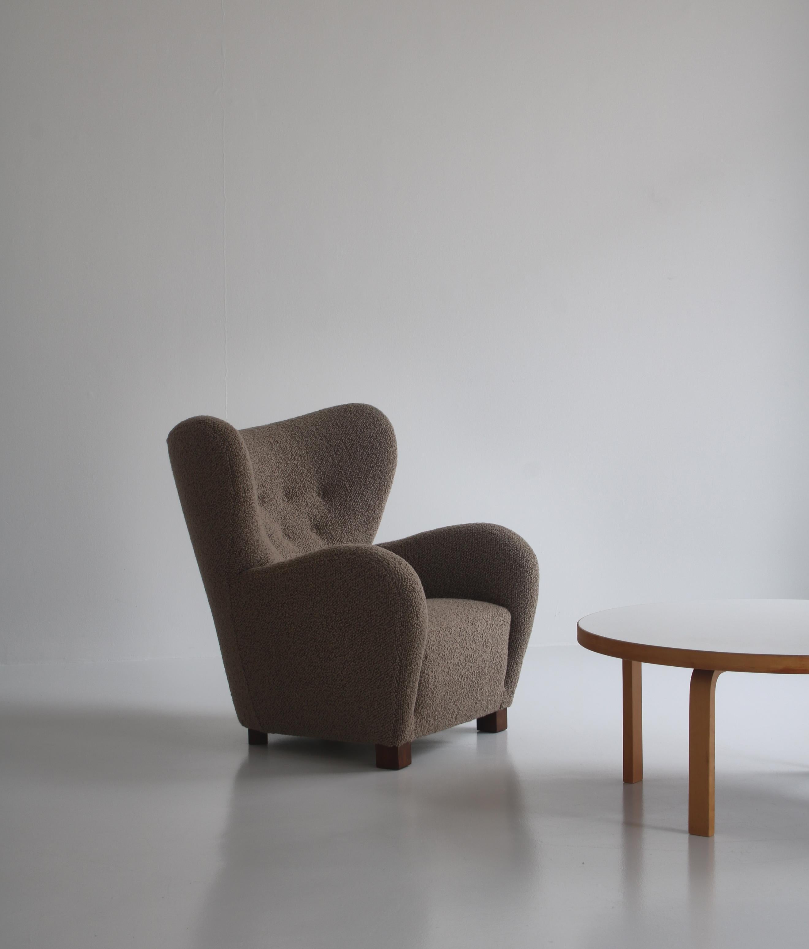 Magnifique fauteuil volumineux attribué à Flemming Lassen, fabriqué dans les années 1940, Danemark. Pieds en hêtre teinté. Rembourré par un maître artisan danois en bouclette épaisse de 