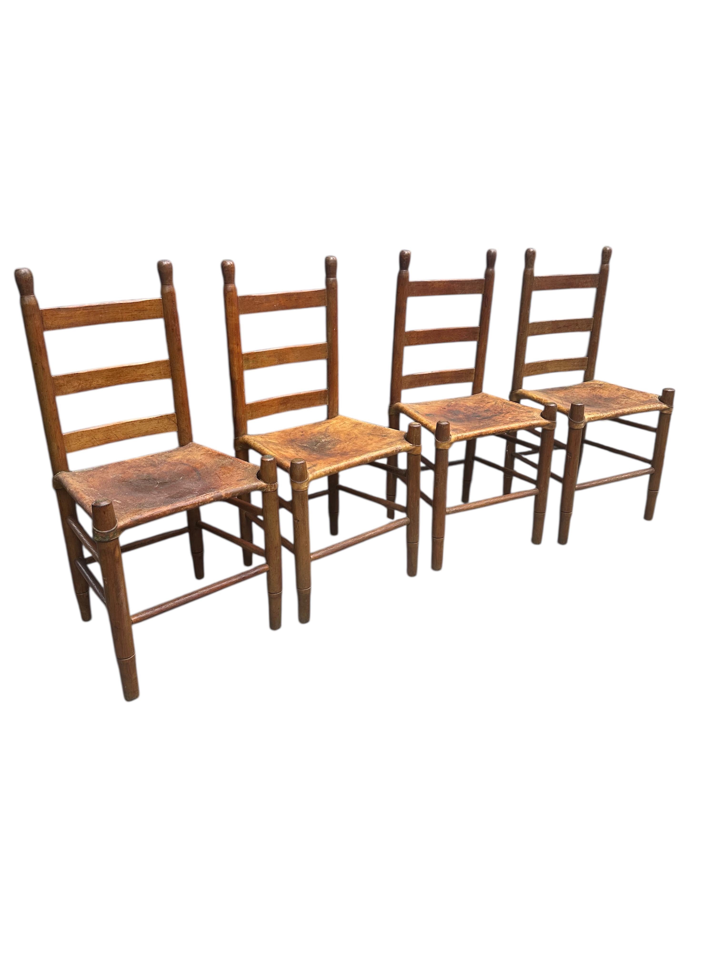 Set of Four Early 20th Century American Ladder-Back Wood and Deer Hide
Chairs.

Antique ladder-back rustic chairs with deer hide seats. The leather is securely laced around a wooden frame, showing the traditional techniques used by skilled artisans.