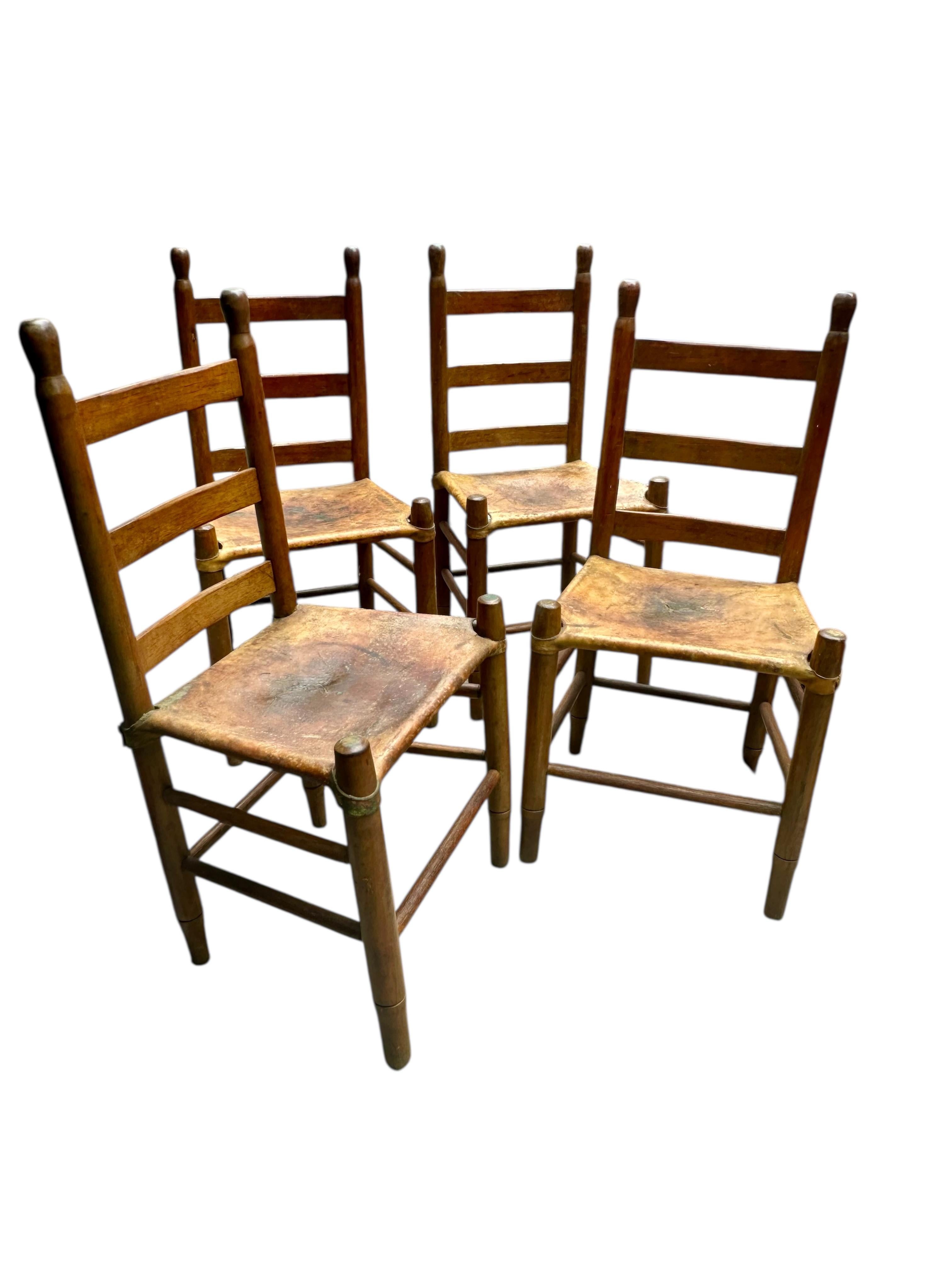 Carved Set of Four Early 20th Century American Ladder-Back Wood and Deer Hide Chairs. For Sale