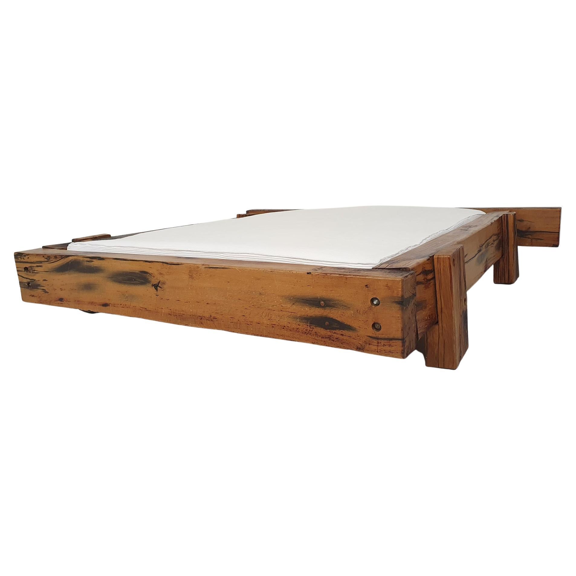 Very nice bed made of heavy solid wooden bars which are attached with bolts.
The wood has a nice patina, at some points the wood is cracked, but this does not affect the structure, it only makes it more beautuful, like it comes straight out of