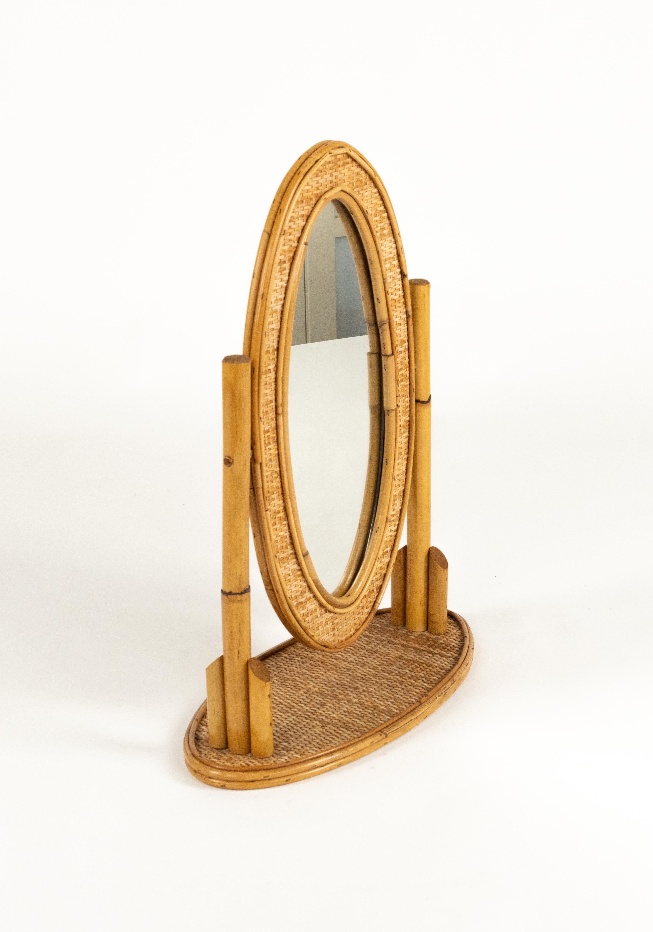 Midcentury beautiful adjustable oval vanity table mirror in bamboo, rattan and wicker.

Made in Italy in the 1970s.