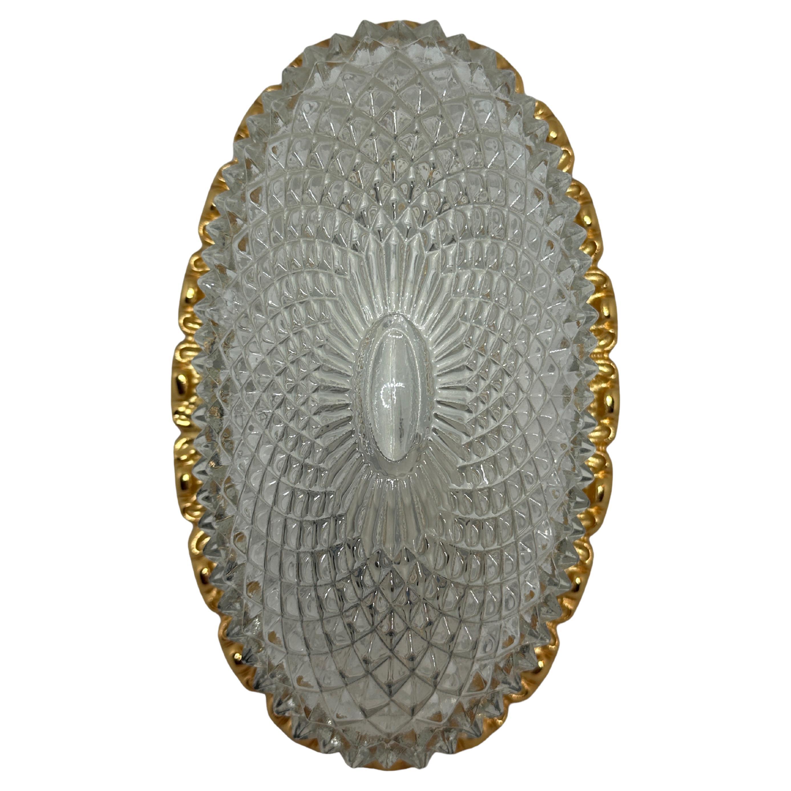 Petite sconce or wall lamp with crystal glass and metal edge gold plated oval 1960s.
Manufactured by Glashütte Limburg in an elegant design. Marked with the original label
A real Design classics, high-quality, thick crystal glass cylinder with
