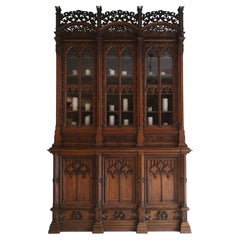 Gran armario o estantería de roble tallado de estilo neogótico alemán, firmado y fechado en 1883