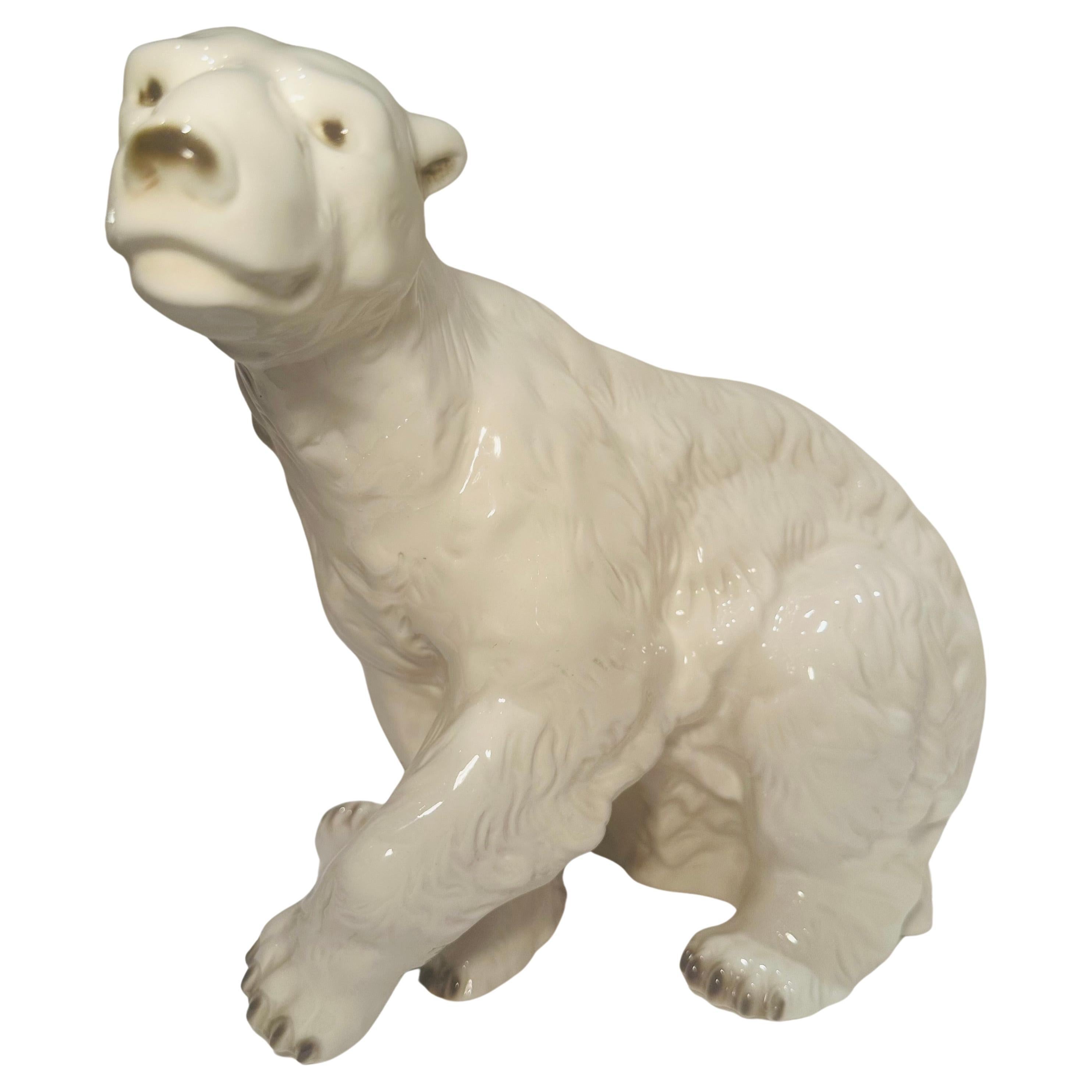 A Royal Dux large hand made and painted porcelain polar bear, 20th century, modeled seated with one paw raised, applied blue triangle mark. Hallmark on bottom indicates circa 1918-1945.

Measures approximately 10.5