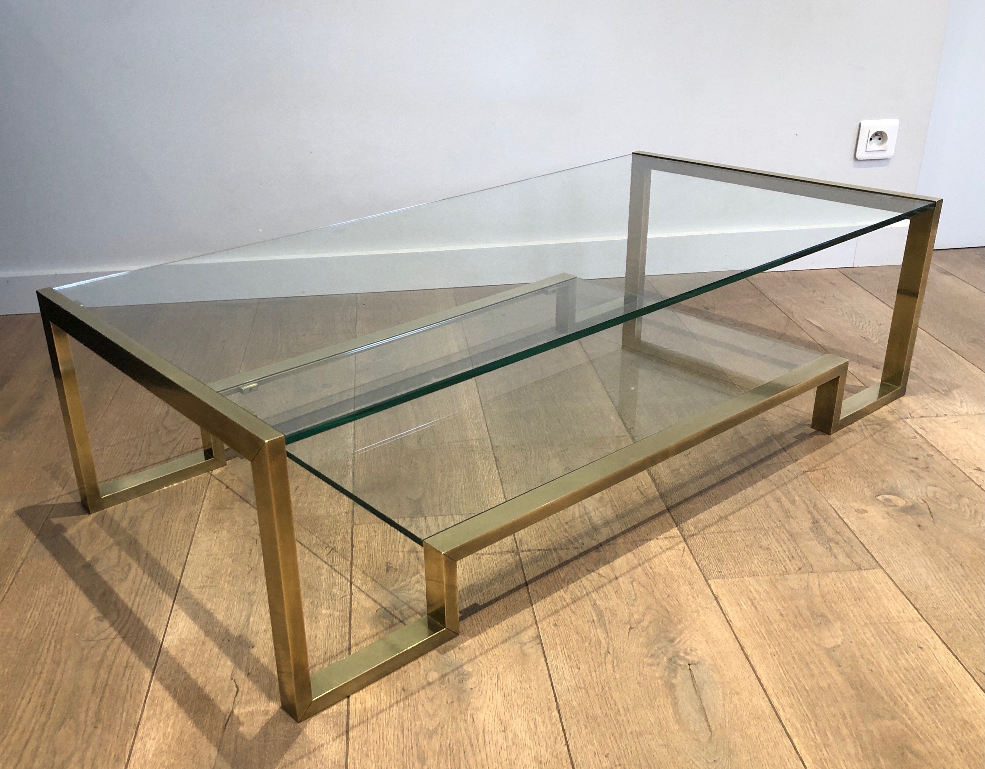 This design coffee table is made of brass with 2 glass shelves. This is a work by famous French designer Guy Lefèvre for Maison Jansen. Circa 1970.
 