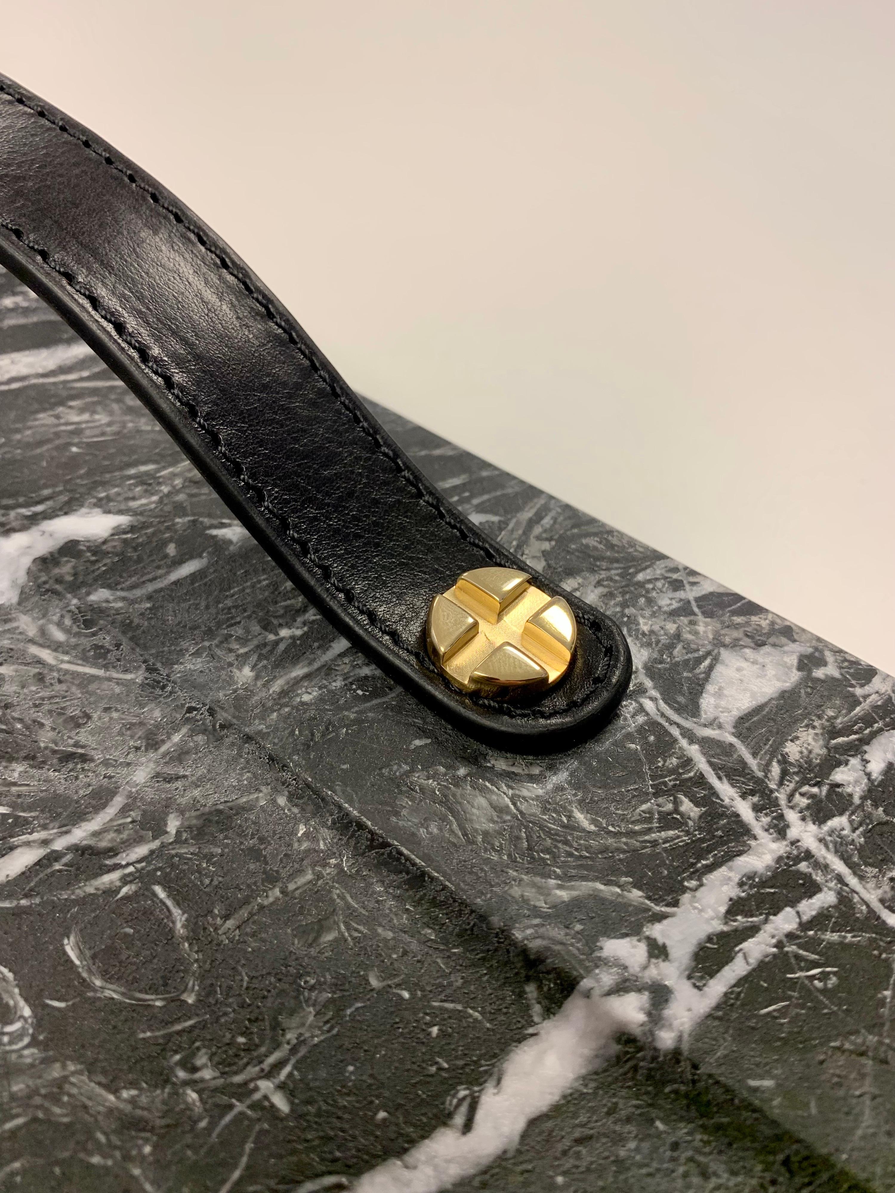 Marble trays with leather straps and brass bottom reinforcement. Leather tips on the legs to avoid scratching surfaces.

Marble is a non-foliated metamorphic rock composed of recrystallized carbonate minerals, most commonly calcite or