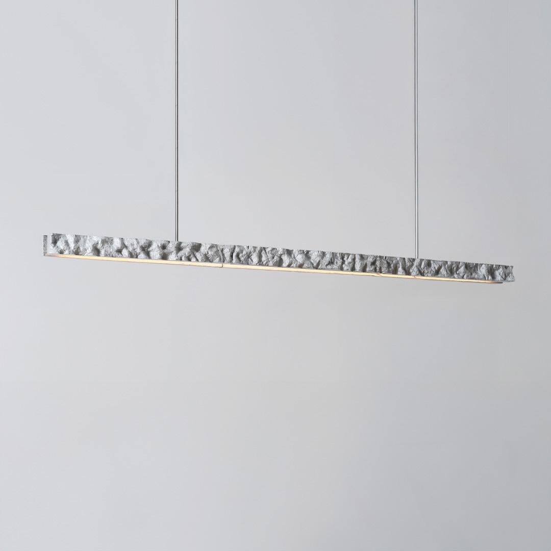Carved + Cast = CARST. The CARST light is made through a unique process where a hand-carved block of aerated concrete is used to create a cast in solid aluminum. 

After the raw cast is formed, the edges are hand polished to produce a contrast