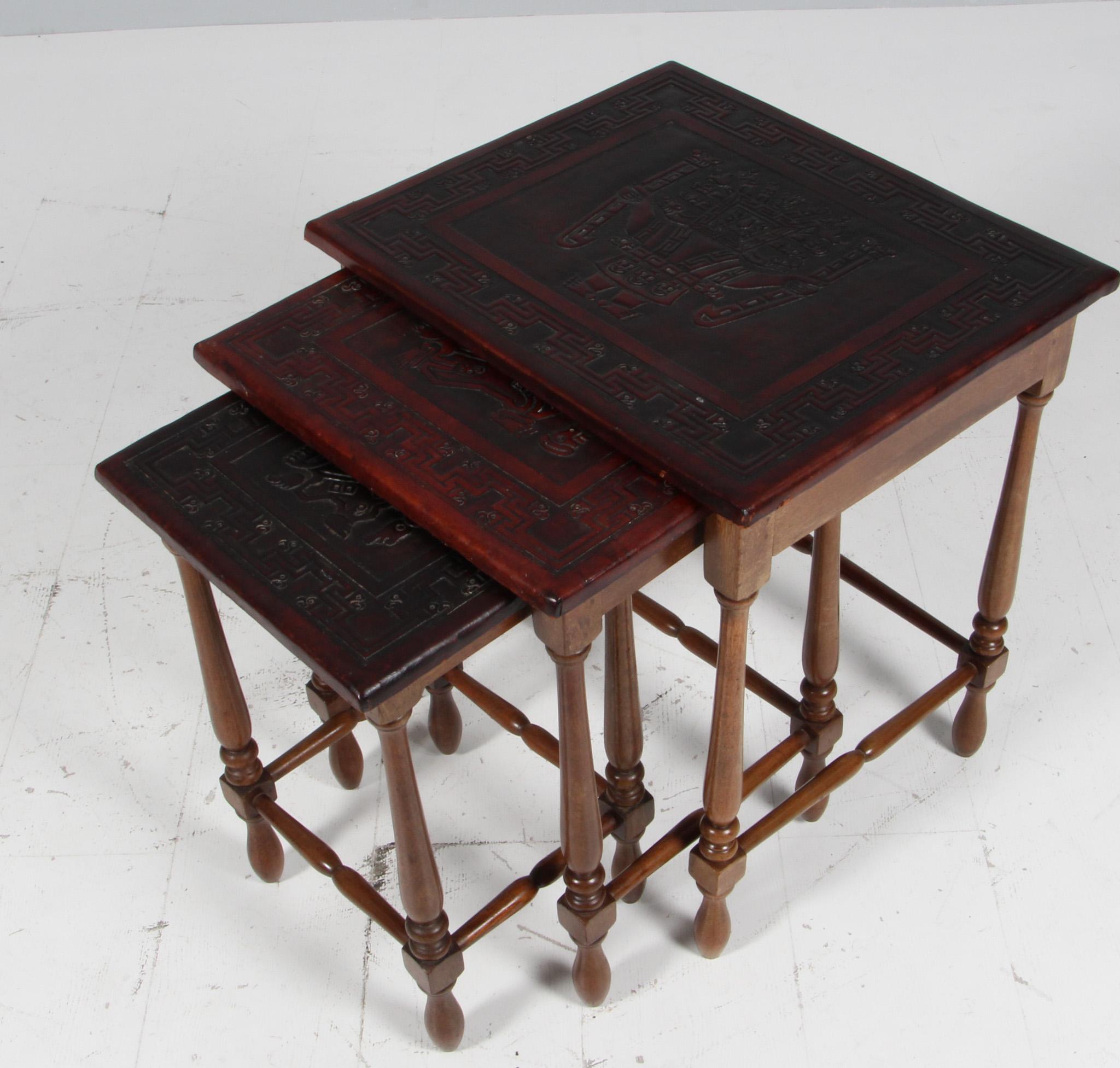 Tables gigognes équatoriennes par Angel Pazmino pour Meubles de Estilo.
Teck massif, plateaux de table en cuir de selle marron gaufré de motifs incas.
Nous proposons une mise en caisse de qualité muséale.
