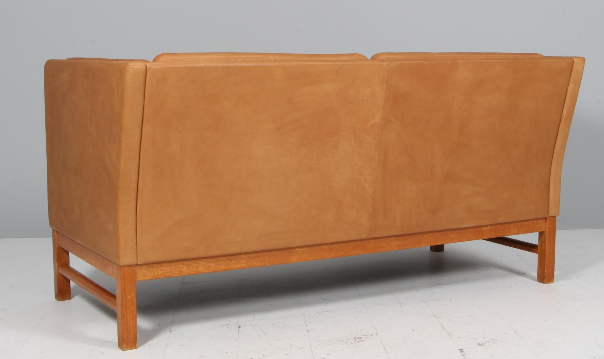 Erik Jørgensen two-seat sofa new upholstered with vintage tan aniline leather.

Frame of oak.

Model EJ 315/2, made by Erik Jørgensen.