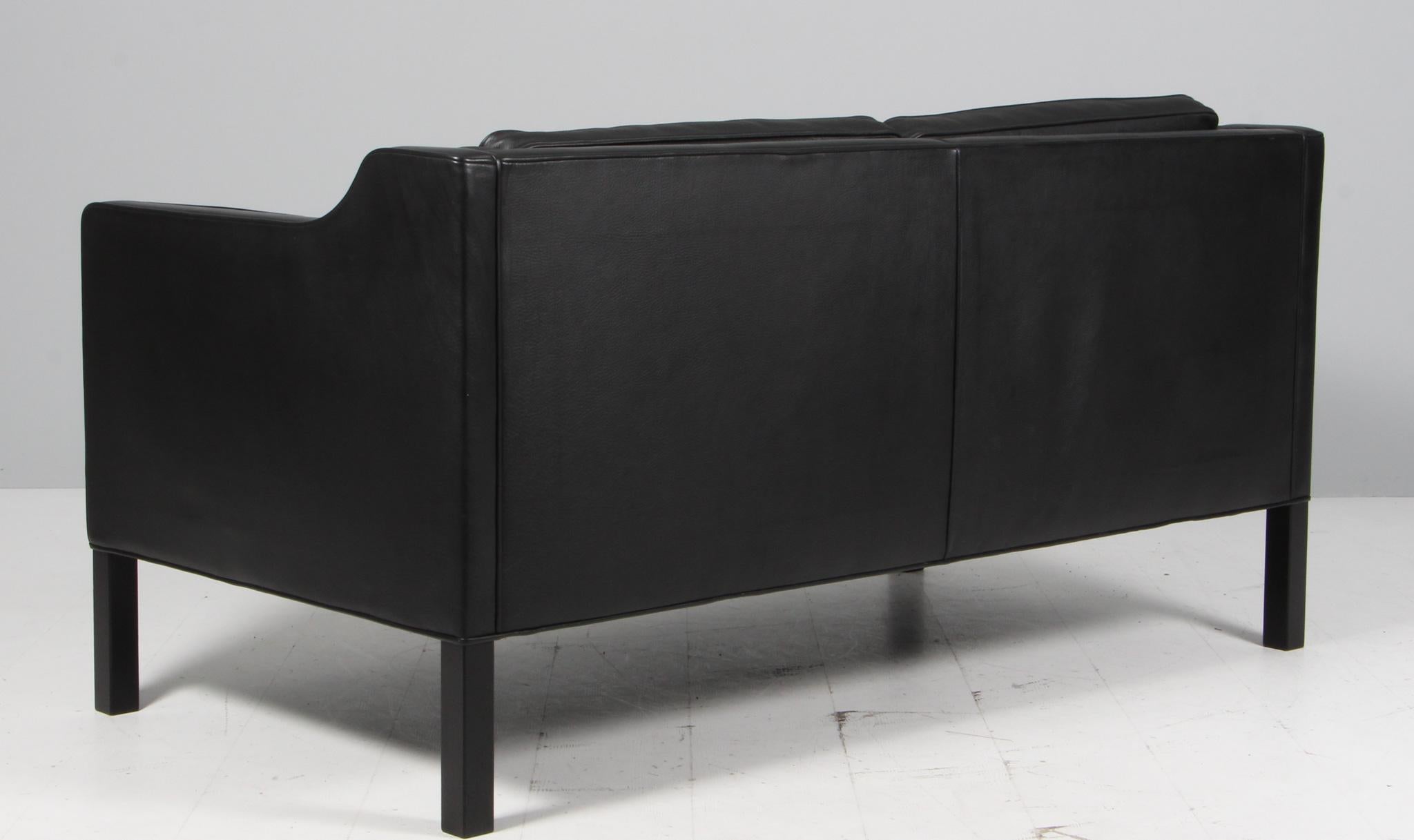 Børge Mogensen two-seat sofa with original leather upholstery.

Legs of black stained oak.

Model 2212, made by Fredericia Furniture.