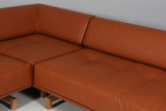 Divano ad angolo Hannes Wettstein in pelle color noce e rovere. Modello Delphi