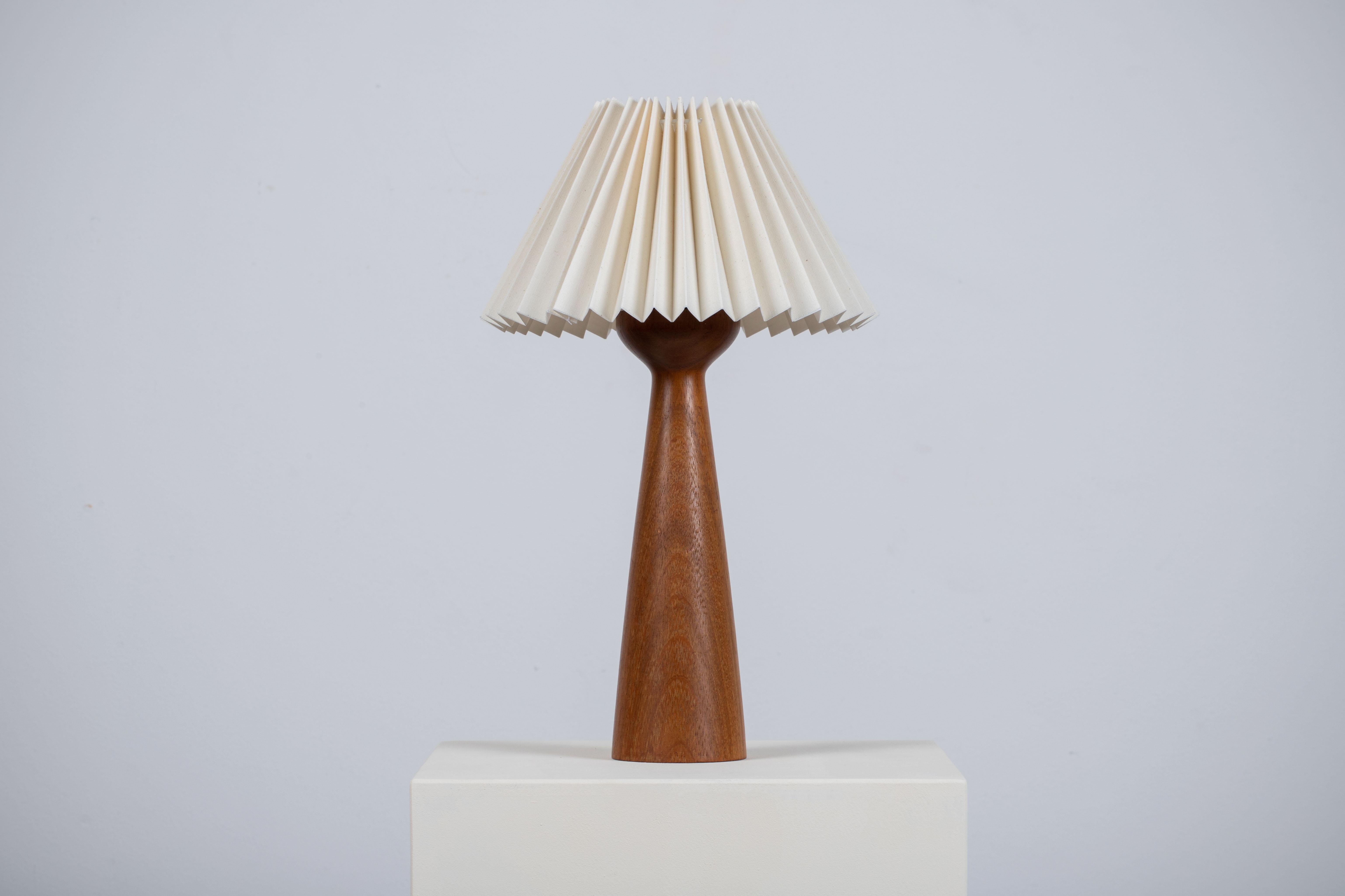 Composition d'un raffinement discret, cette lampe de table danoise du milieu du siècle révèle un langage d'un modernisme tranquille et d'une clarté sculpturale. Attribuée à Uno Kristiansson, la pièce est exécutée en teck massif - sa forme effilée