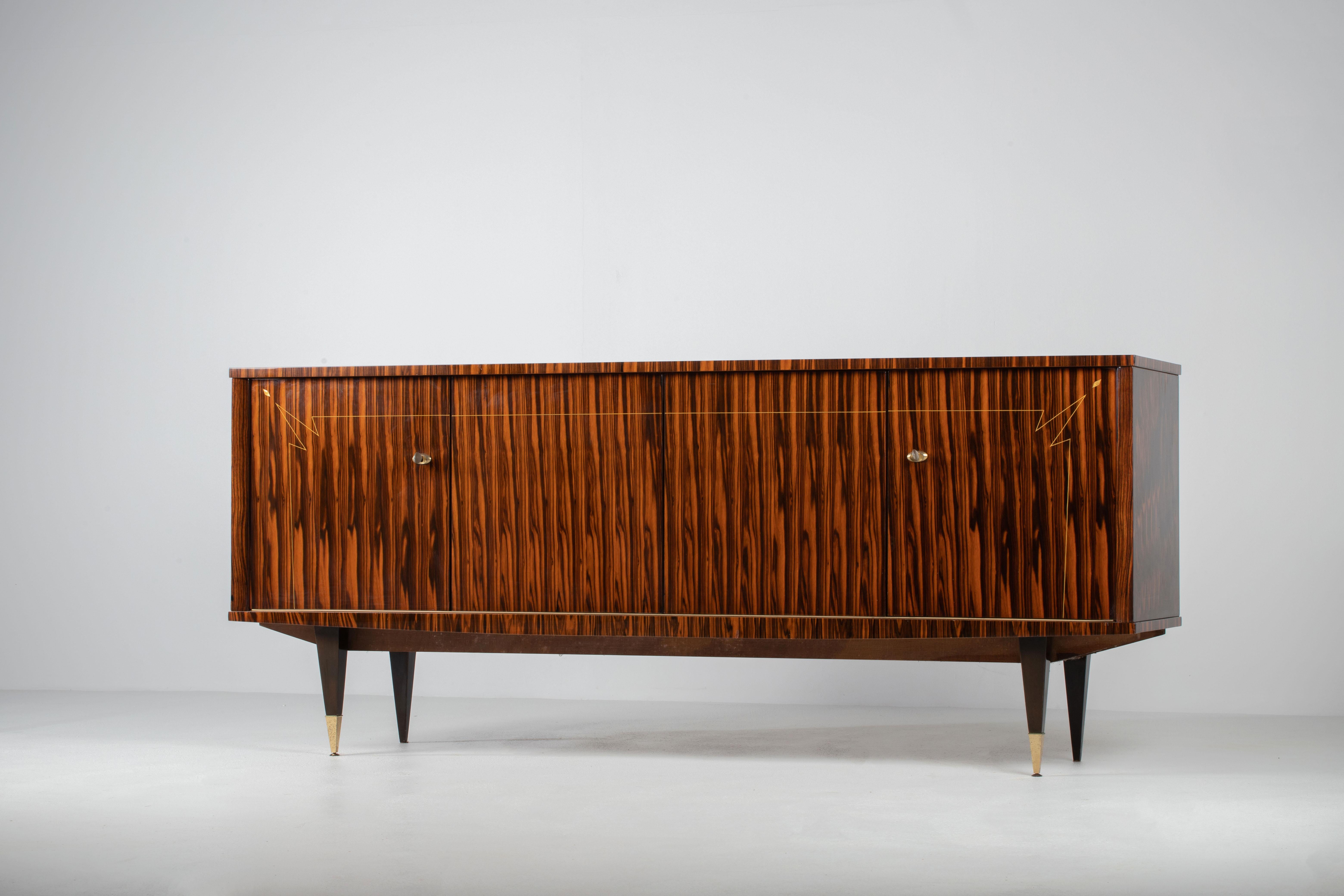 Uno studio sul ritmo misurato e sulla materialità raffinata, questa credenza francese rivela un linguaggio di sobrietà e tranquilla raffinatezza. Ancorata a una cassa di proporzioni generose, la composizione si sviluppa attraverso una facciata