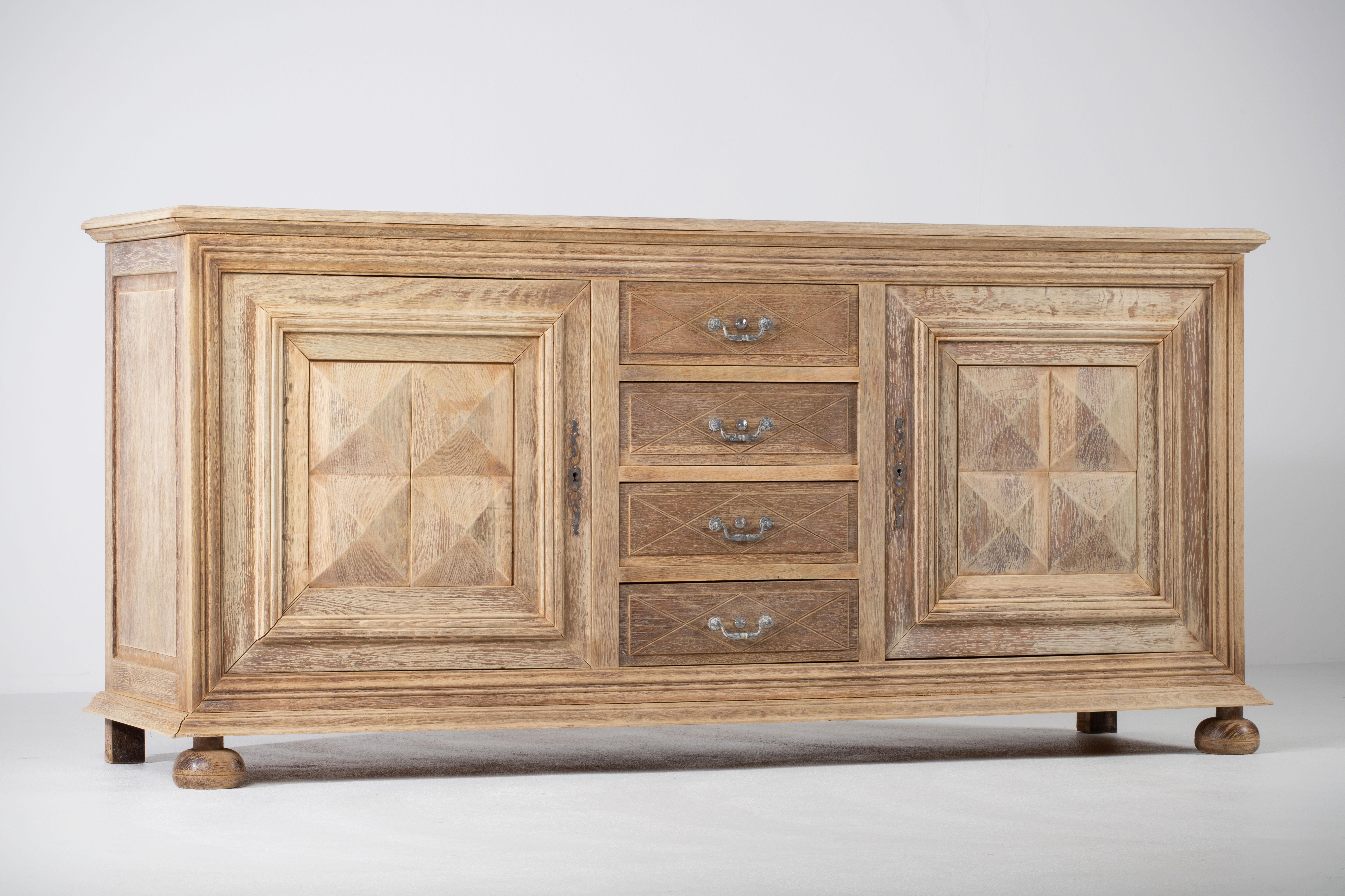 Testimonianza dell'intramontabile chiarezza dell'artigianato francese di metà secolo, questo buffet in rovere sbiancato rivela un linguaggio di quiete scultorea e ritmo architettonico. Selezionato con cura per la sua singolare presenza, il pezzo non