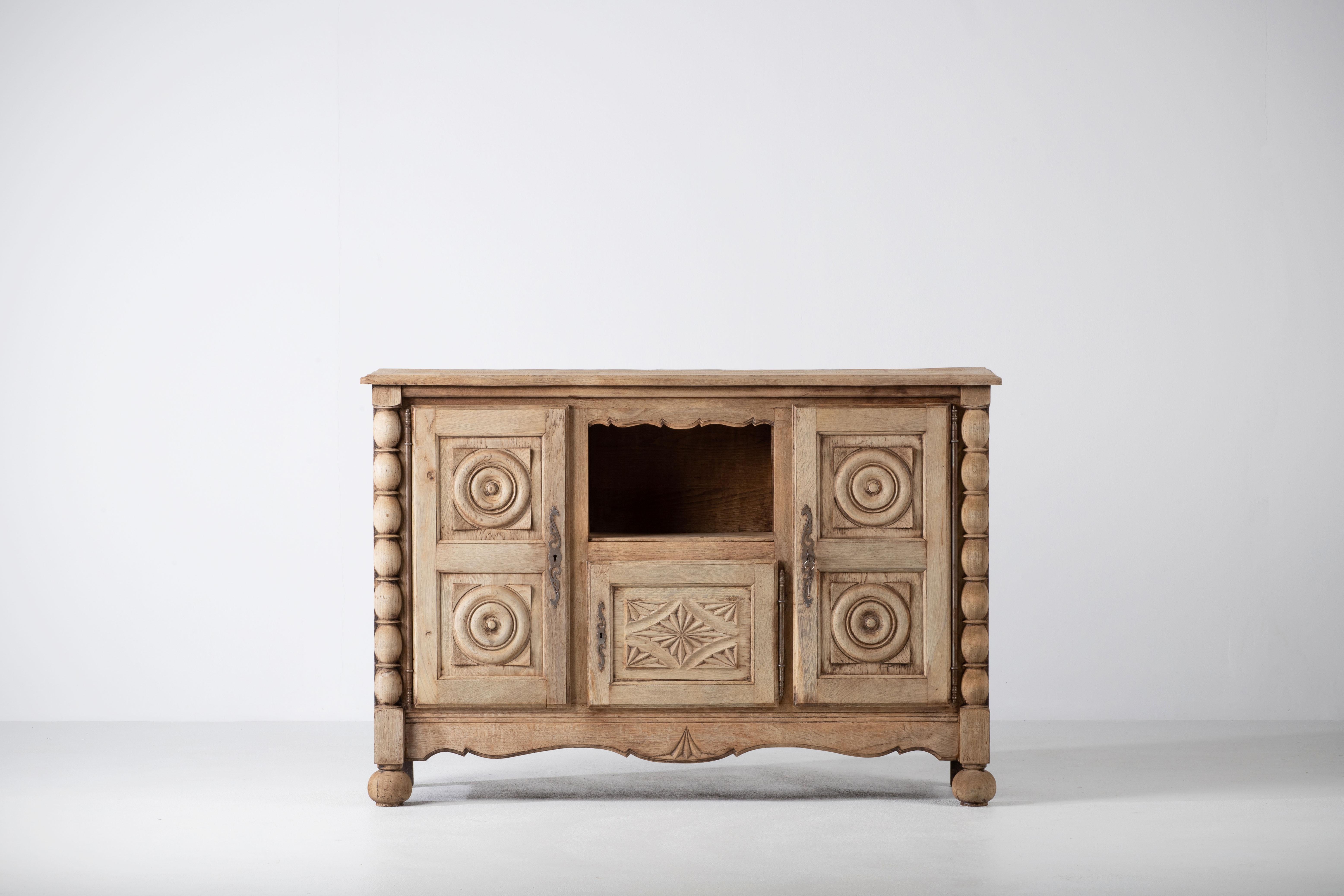 Dieses bretonische Sideboard ist eine Studie über die Beständigkeit der Provinz und zeigt eine Sprache der skulpturalen Solidität und der zurückhaltenden Ornamentik. Das in der Normandie gefundene Möbelstück verkörpert die ruhige Autorität der