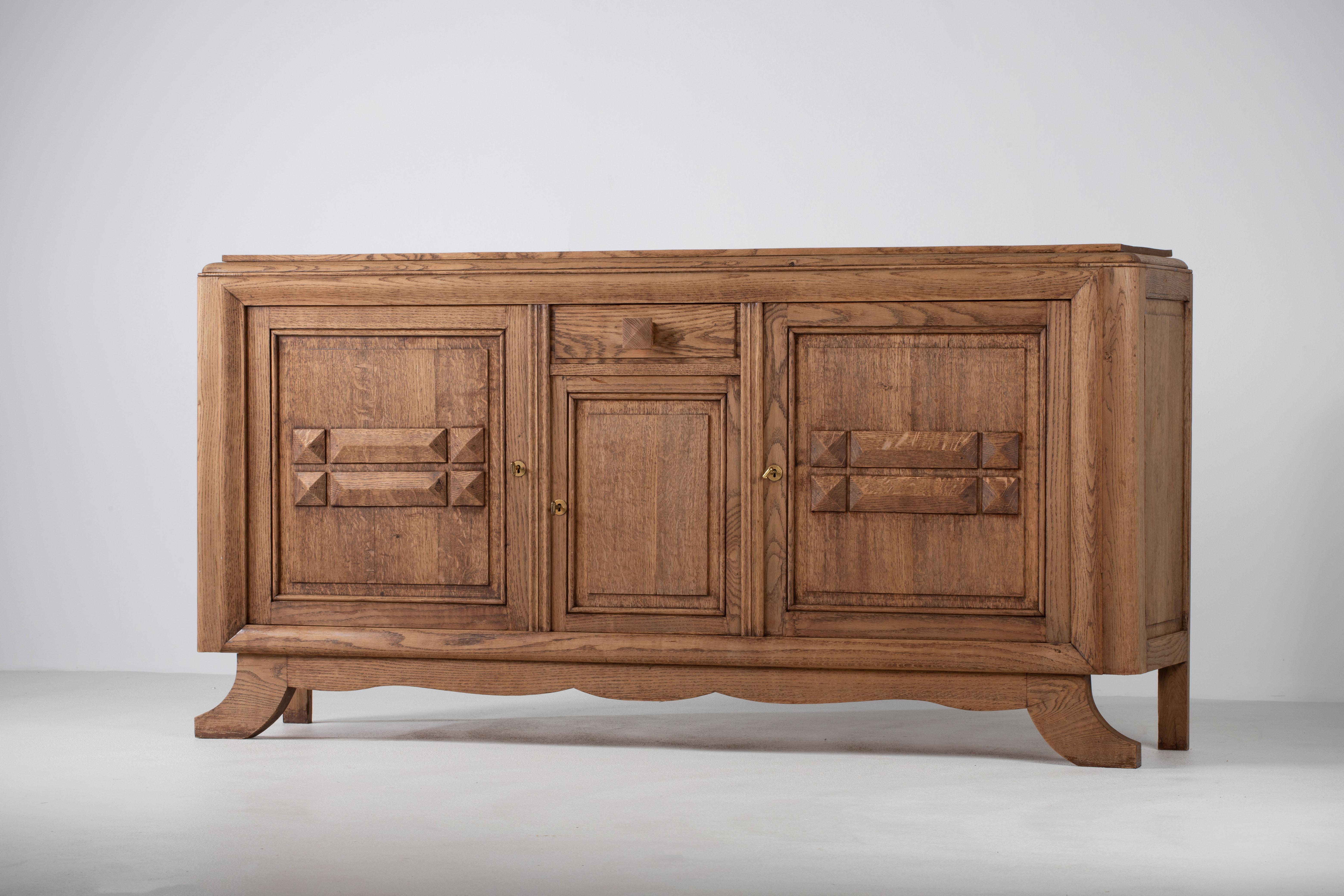 Metà XX secolo Una composizione di tranquilla permanenza: Credenza in Oak francese con ante intagliate in vendita