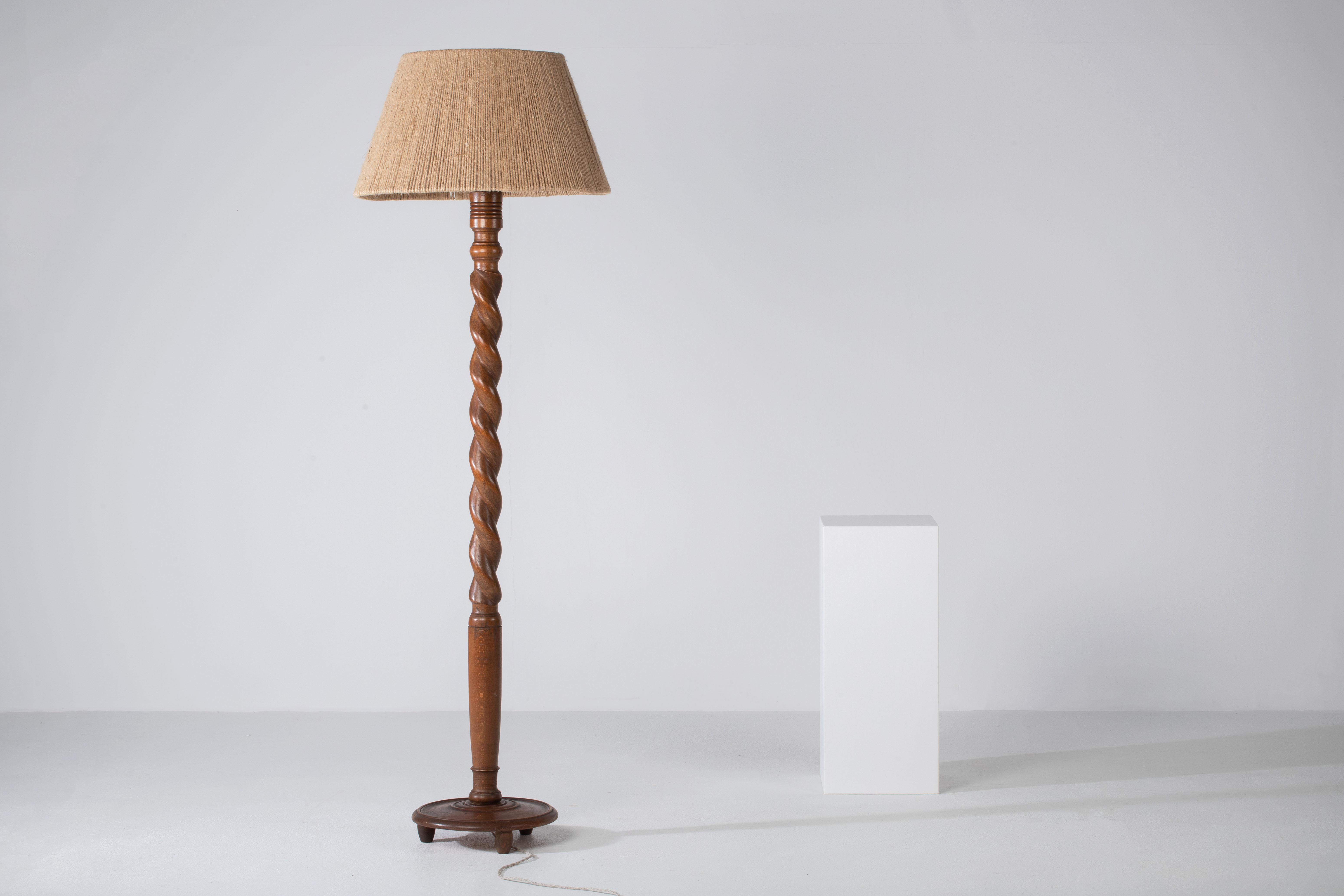 Una composizione di discreta compostezza, questa lampada da terra francese rivela un linguaggio di sobrietà scultorea e ritmo organico. Sorgendo da un fusto contorto di quercia massiccia, la forma comanda la presenza non attraverso l'abbellimento,