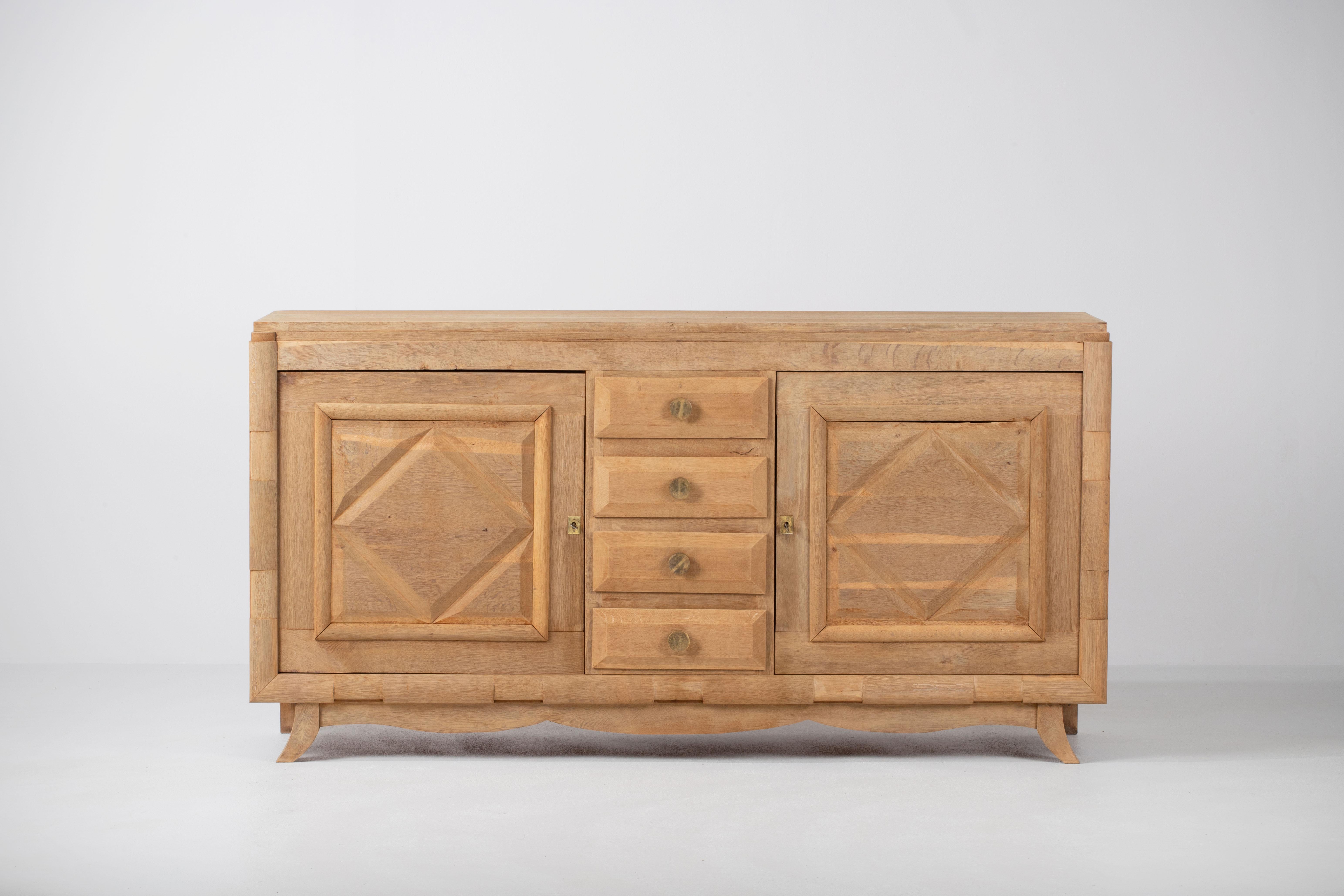 A composition of stoic elegance, this French credenza reveals a language of sculptural rhythm and measured clarity. Framed in the quiet discipline of 1940s cabinetmaking, the piece commands presence not through ornament but through the repetition of