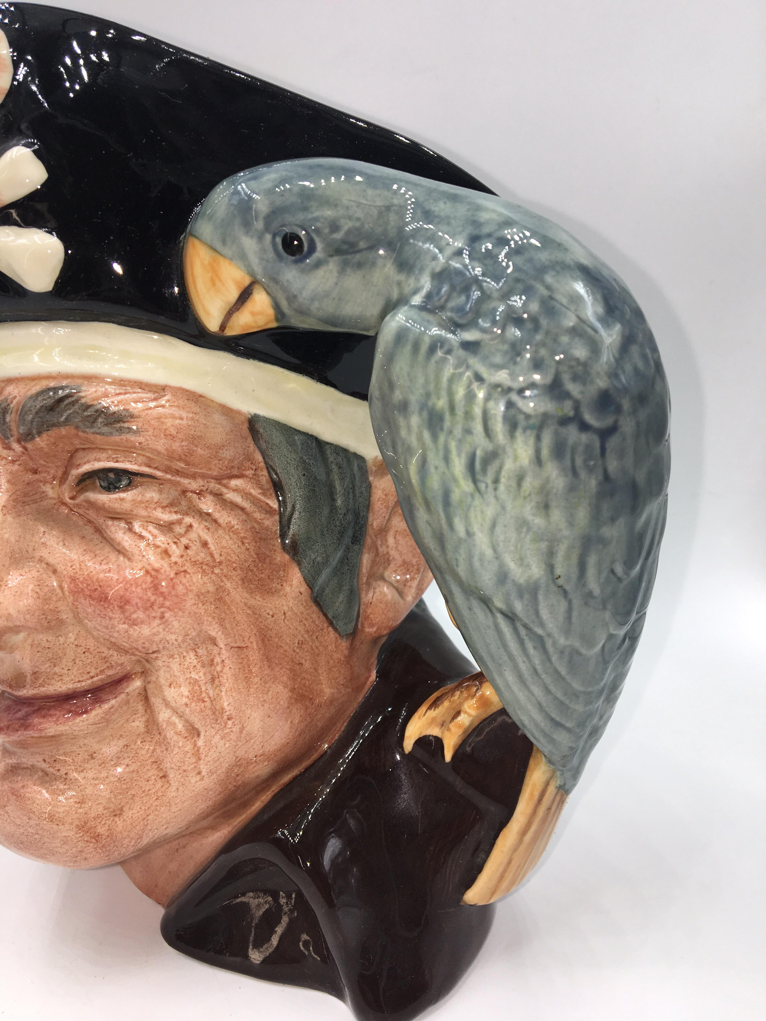 This is an offer of a really great Royal Doulton jug - this one of Long John Silver (and his parrot).
The underside stamps suggest this design is from their 'Characters From Literature' series and this design is by Max Henk.
D6335 1951 porcelain