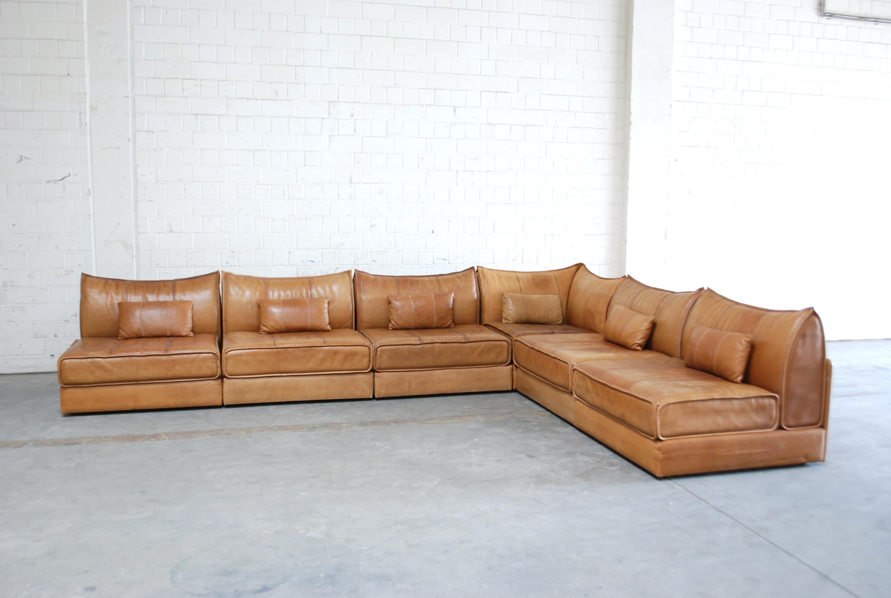 De Sede Ds 19 modul sofa. Thick cognac leather as known as DS military leather. Unique colour and patina.
It consists 6 elements including 1 corner and 5 single elements and 6 small pillows. Rare model by De Sede.
De Sede is known for best leather