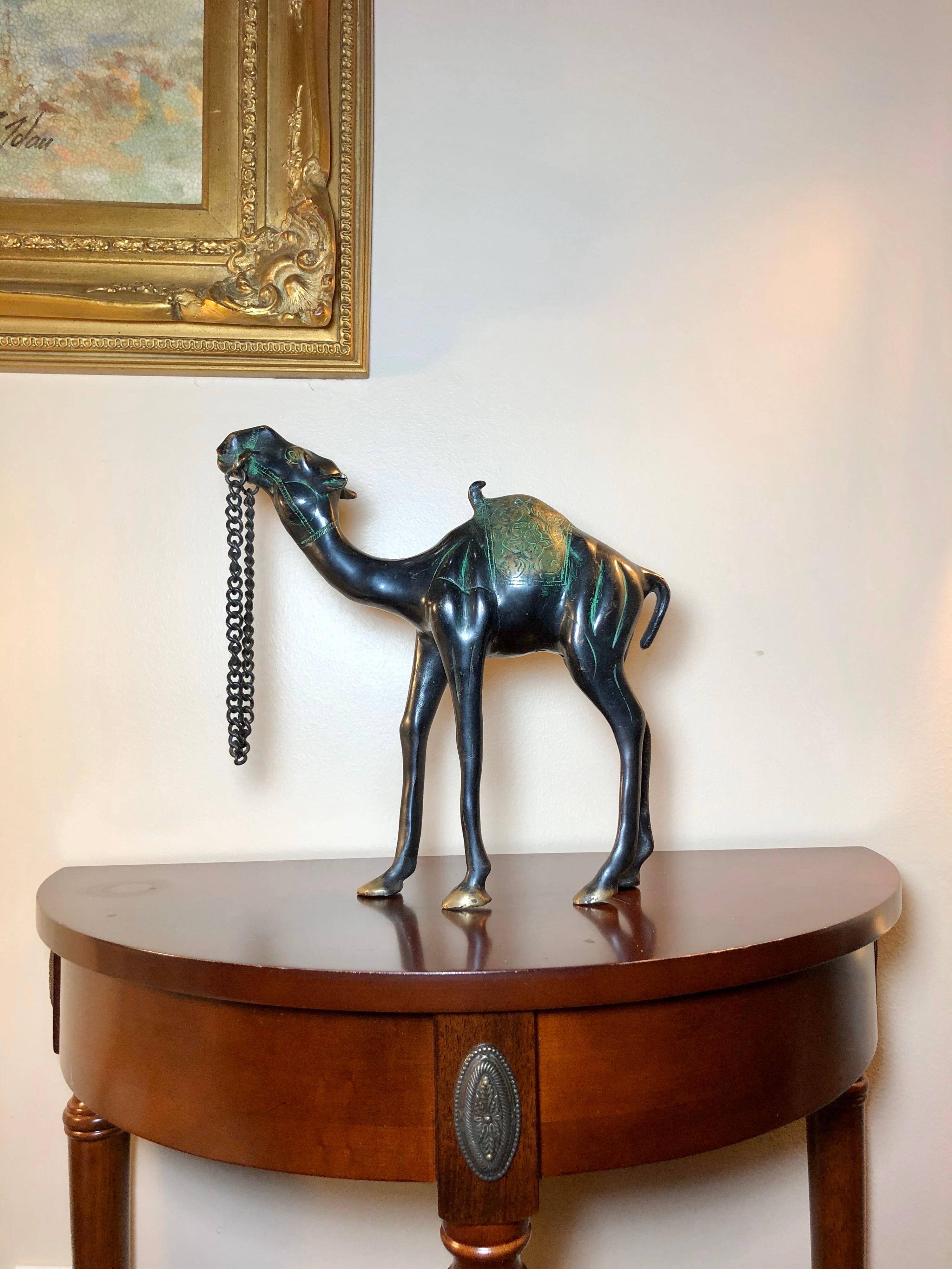 Stunning antique bronze sculpture of a camel saddled up and ready to cross the Sahara Desert. Ornately detailed, with the saddle and musculature handsomely defined by engraving and polishing. The natural green patina adds further beauty and