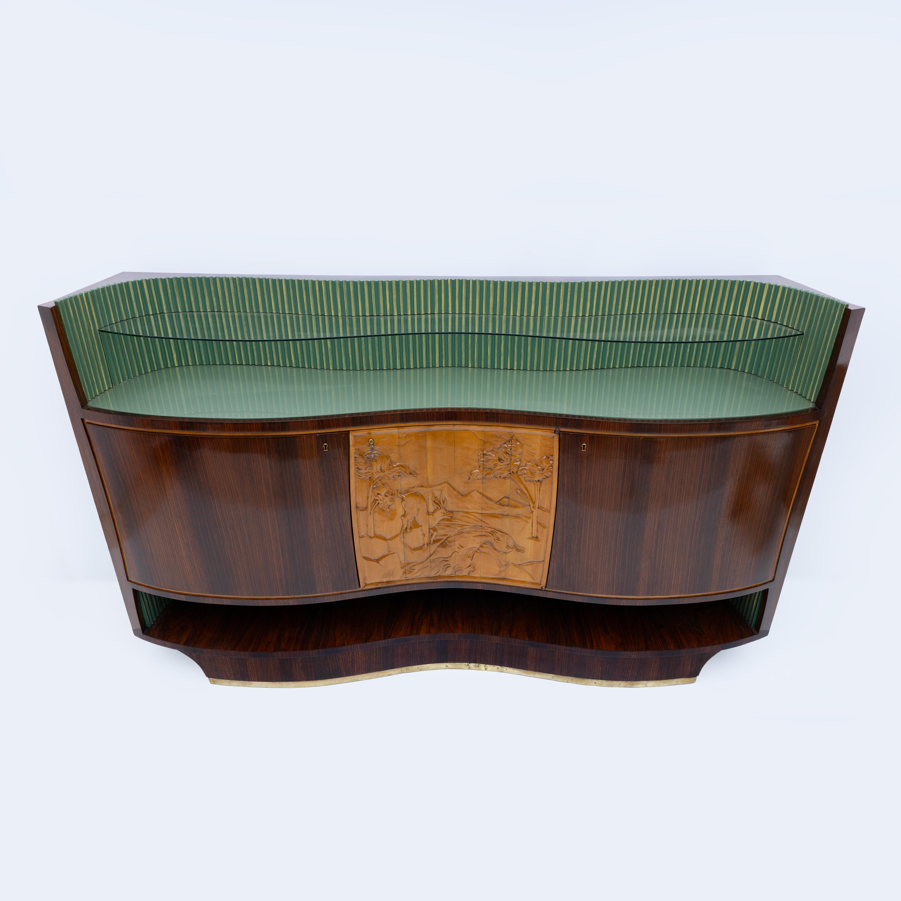  Questo mobile bar è stato progettato dal famoso designer italiano Vittorio Dassi, Italia, 1950. Il mobile è in noce con ripiani in vetro trasparente e verde, l'anta centrale è in acero intagliato per rappresentare un'immagine della natura, mentre