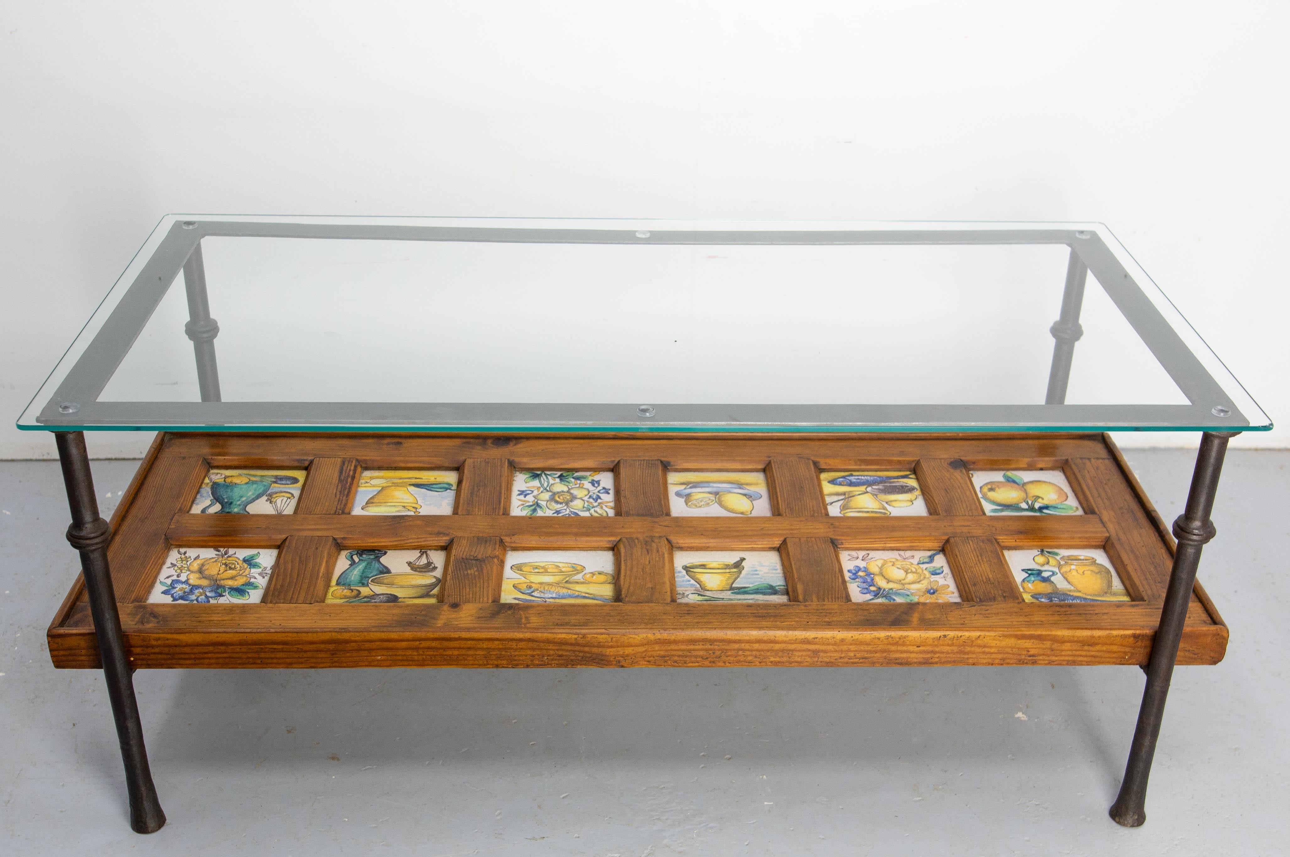 Pine, ceramic, wrought iron & glass coffee table, from Spain, midcentury.
The table was made circa 1960 but the 12 faience tiles were made in the late 19th century.
They are part of a still life theme, with three tiles ornated this flowers.
Each