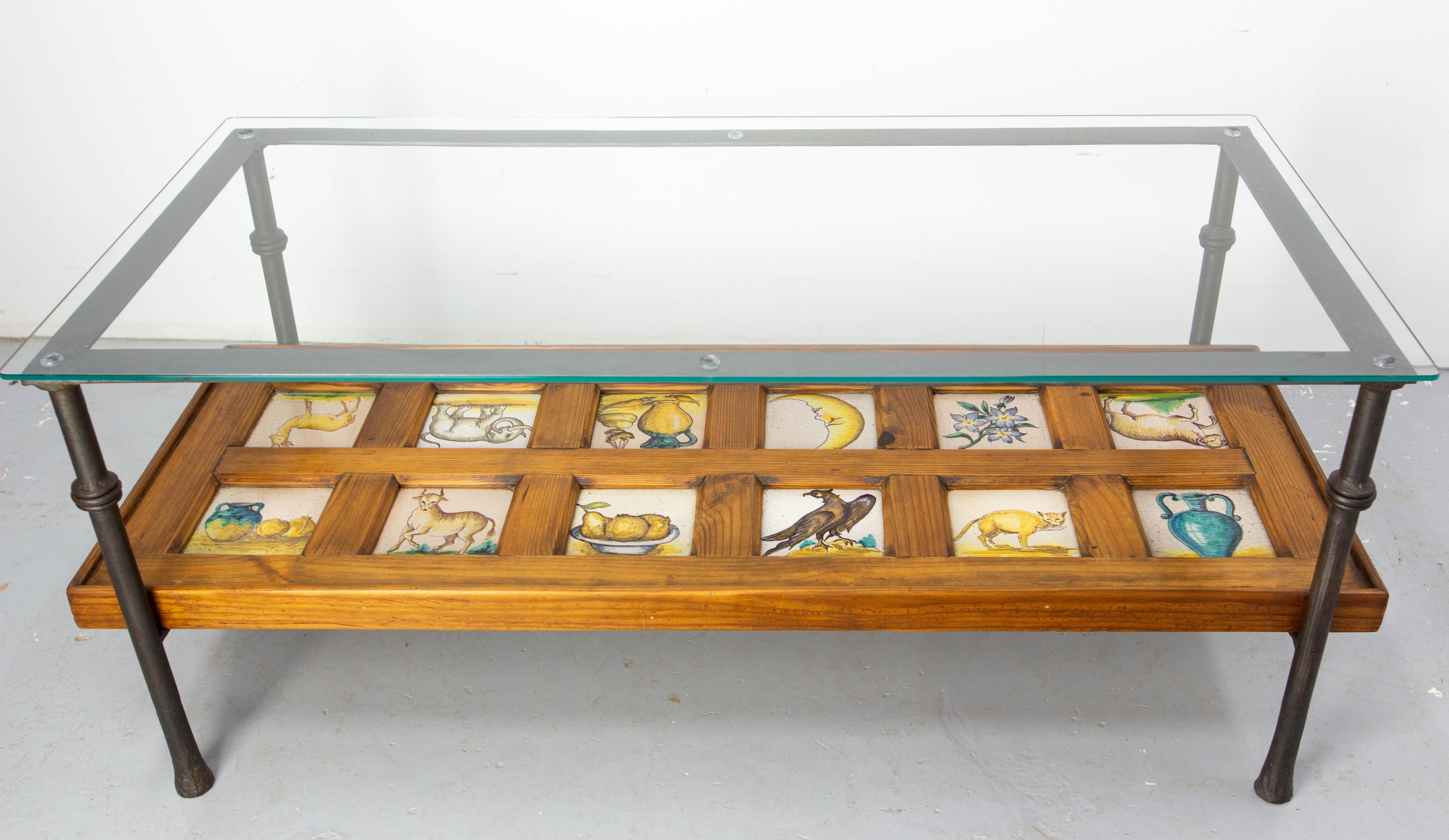 Table basse en pin, céramique, fer forgé et verre, Espagne, milieu du siècle.
La table a été fabriquée vers 1960 mais les 12 carreaux de faïence ont été fabriqués à la fin du 19e siècle.
Ils font partie d'un thème de nature morte, avec trois