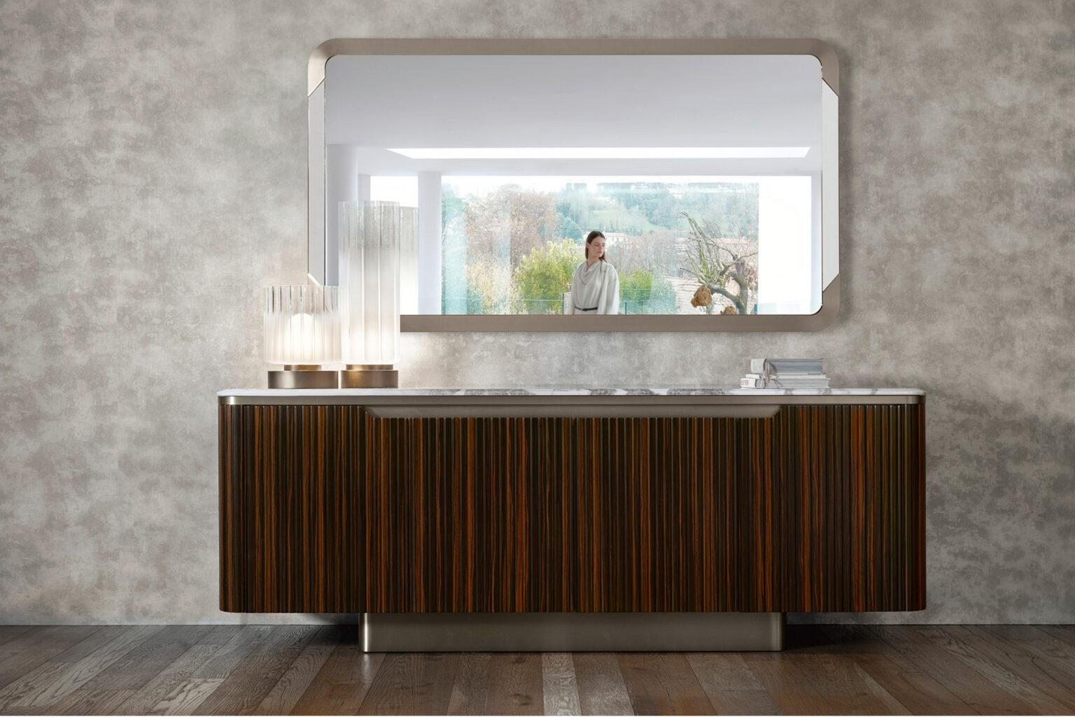 Aparador con 4 puertas en chapa de ébano de Makassar satinado acanalado. Encimera biselada de mármol Ostra de Namibia con acabado brillante. Base y detalles de acero inoxidable galvanizado satinado acabado titanio. 1 cajón interior de extracción