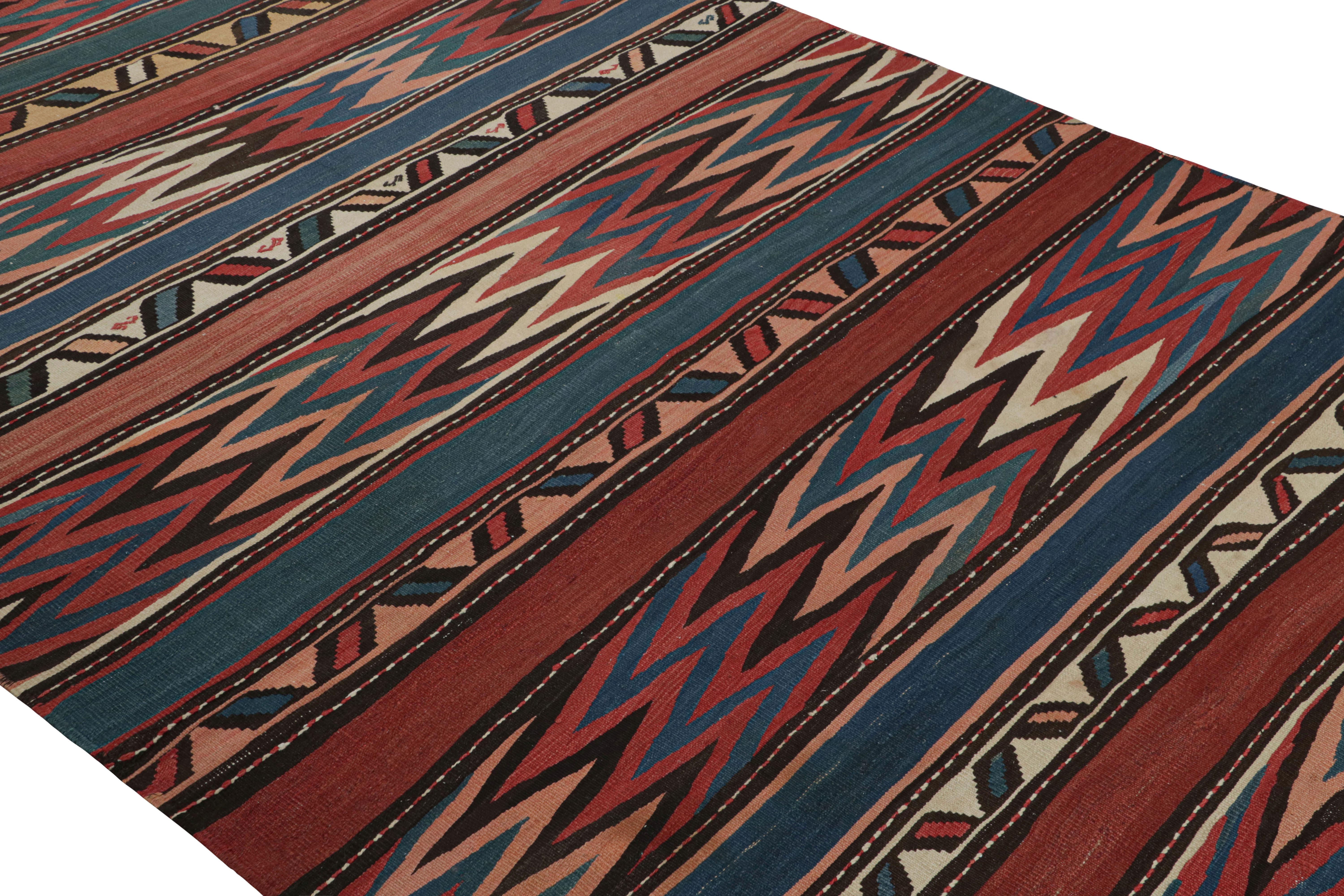 Handwoven between 1950-1960, this vintage midcentury 6 x 14 wool Kilim was discovered in Turkey, enjoying a Shahsavan Persian tribal design denoting a nomadic, diverse origin. The arresting colorway, including rich varied notes of crimson and