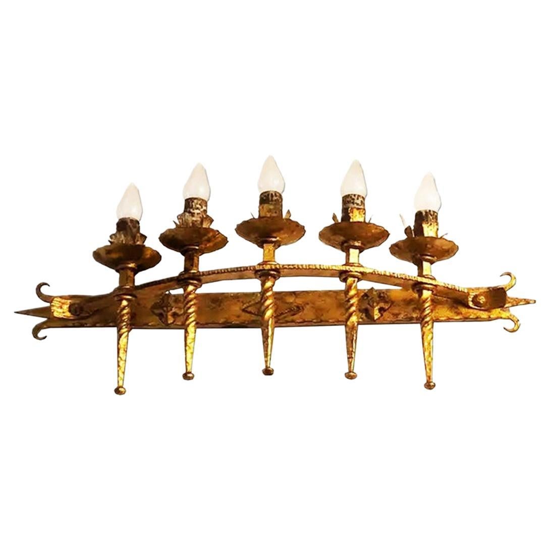 Torch row wall light, golden wrought iron. Brutalist style

Comes from the lighting of a Catholic church

Brutalism is an architectural style that emerged from the Modern Movement and had its peak between the 1930s and 1950s. In its beginnings