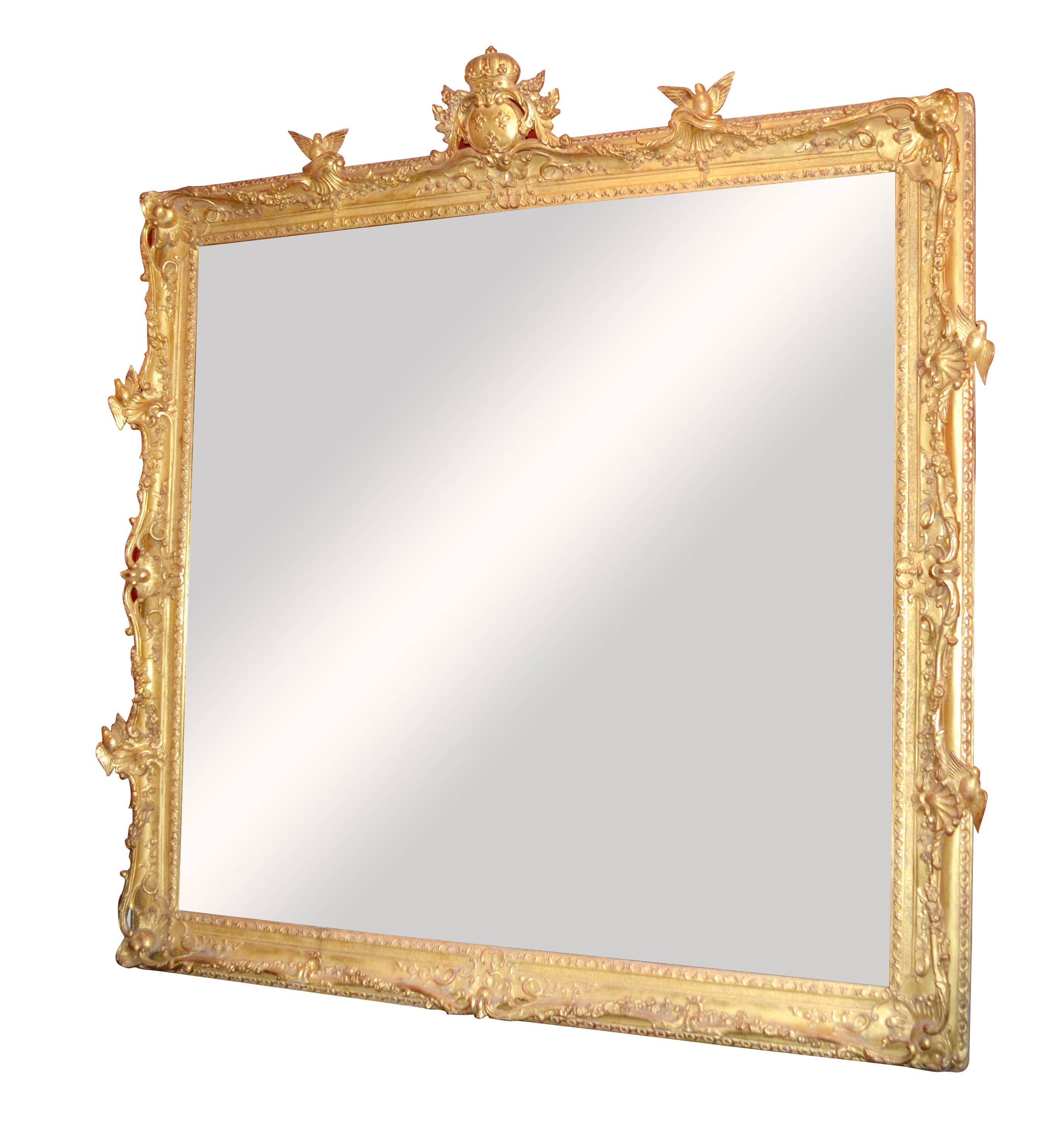 Un grand cadre de miroir magnifiquement sculpté et doré dans le style Louis XV ; une sculpture ouverte sur les côtés et les coins avec deux oiseaux sculptés sur chacun des quatre côtés, le haut décoré d'un cartouche central montrant trois fleurs de