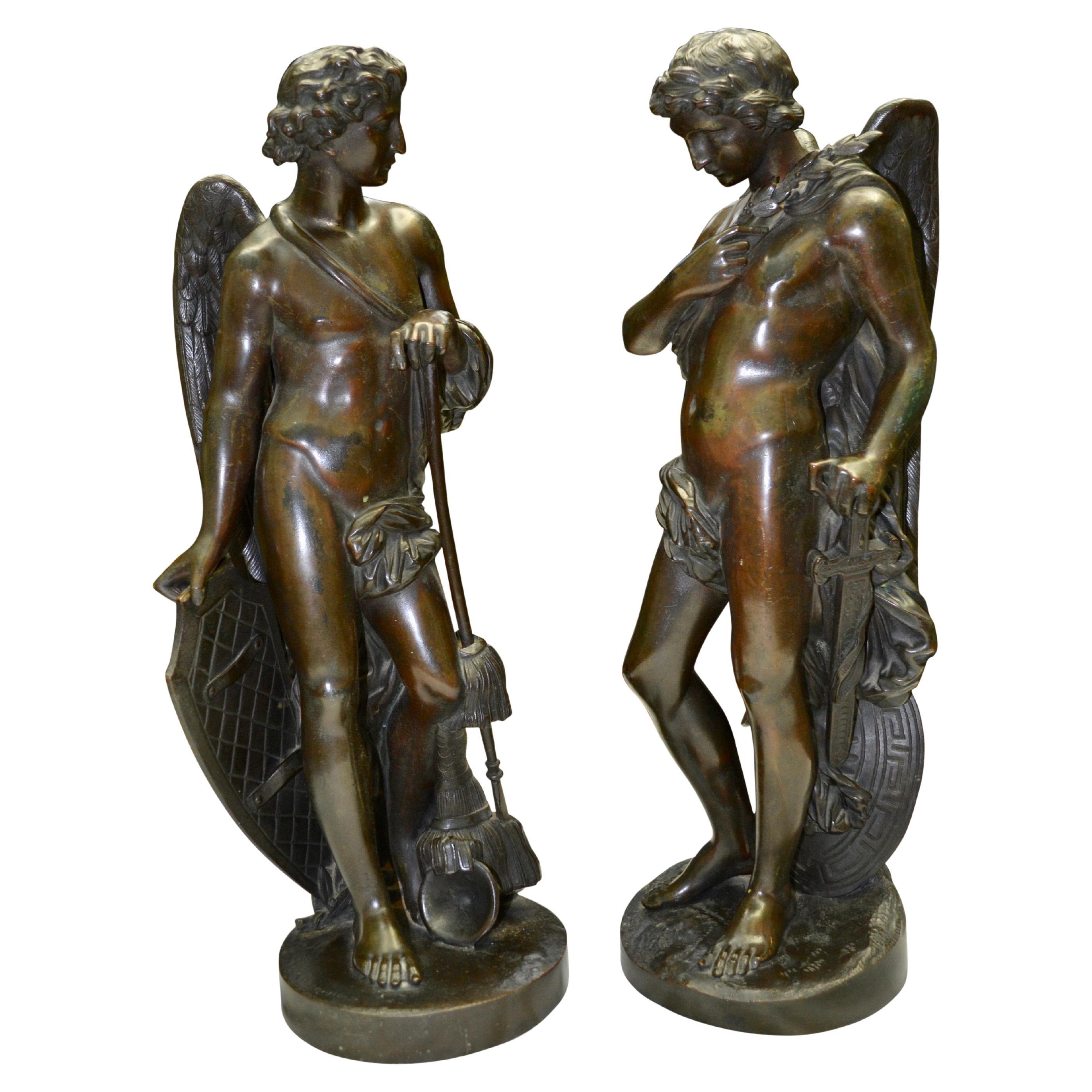 A complimentary pair of beautifully cast and rare standing Greco-Roman patinated bronze statues of winged mostly nude but partly classically draped male figures that are surprisingly unsigned. 

One of the figures is looking down and is holding a