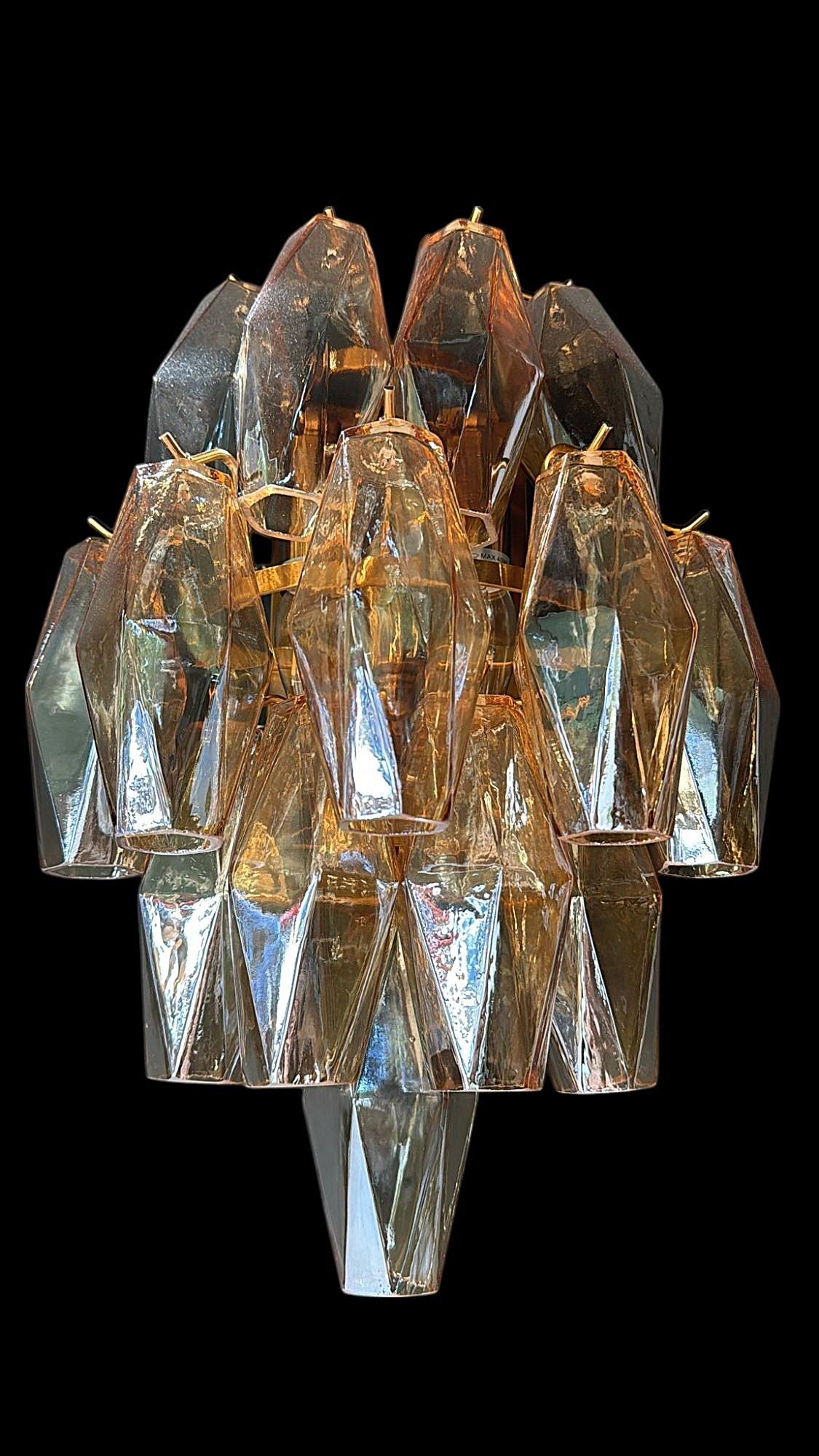 Elegante applique italiana realizzata nei primi anni 2000 da un laboratorio artigianale di vetro di Murano, caratterizzata da una struttura in ottone dorato che sostiene una cascata di elementi in vetro di Murano soffiato a mano. I componenti in