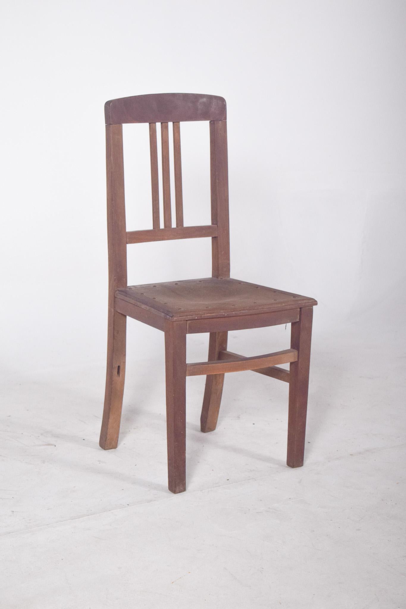 Chaise en bois avec assise clouée. Un modèle classique que l'on retrouve dans les salles de classe du Brésil entre les années 1950 et 1980. Le dossier est composé de trois lattes verticales et d'une barre supérieure légèrement incurvée, ce qui