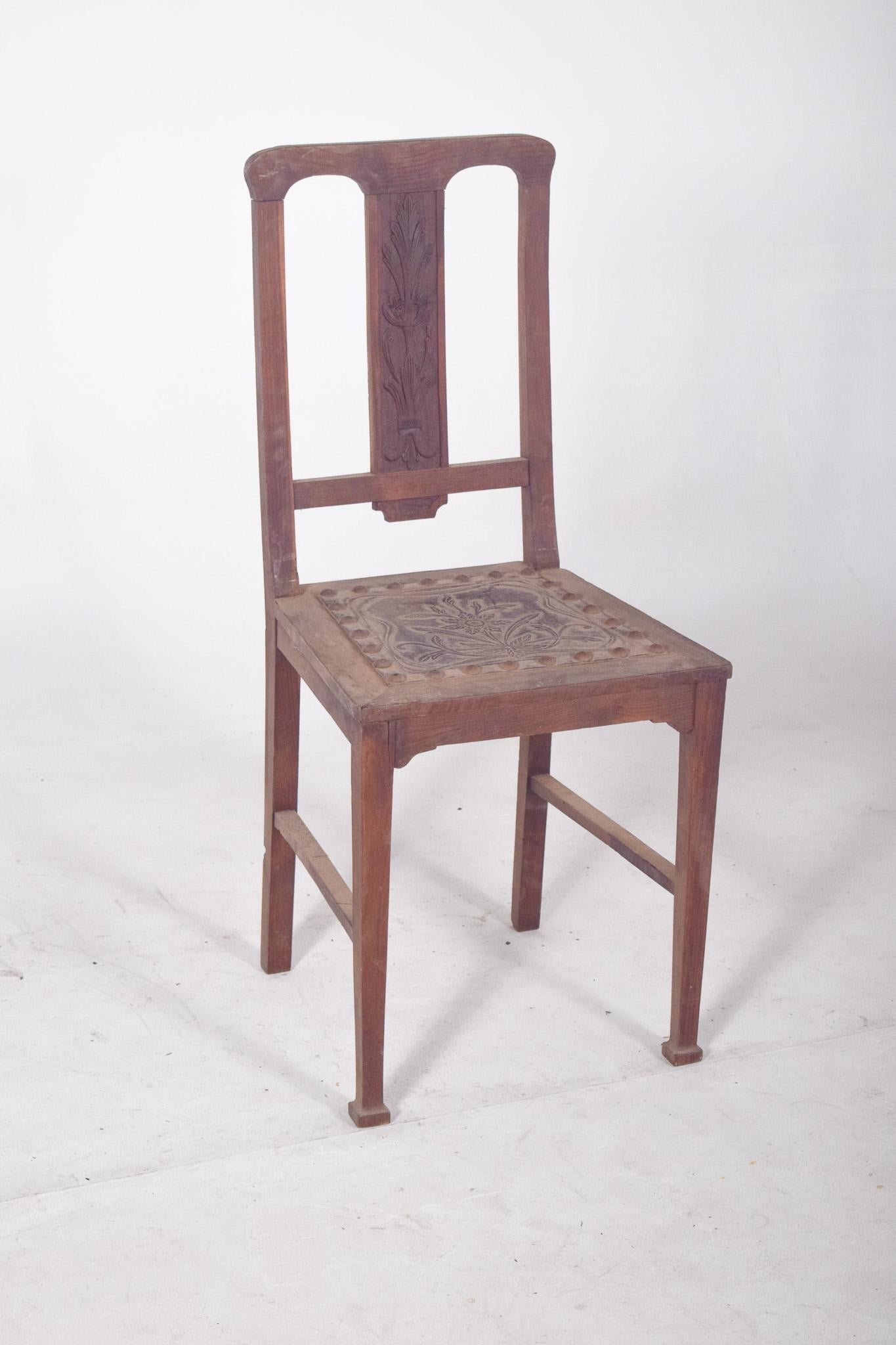 Sedia con seduta e chiodi in rilievo. Ha uno schienale dritto ed è composto da tre aste verticali, di cui quella centrale è allungata e riccamente decorata con un intaglio a bassorilievo di un motivo vegetale. La seduta, anch'essa in legno, ha una