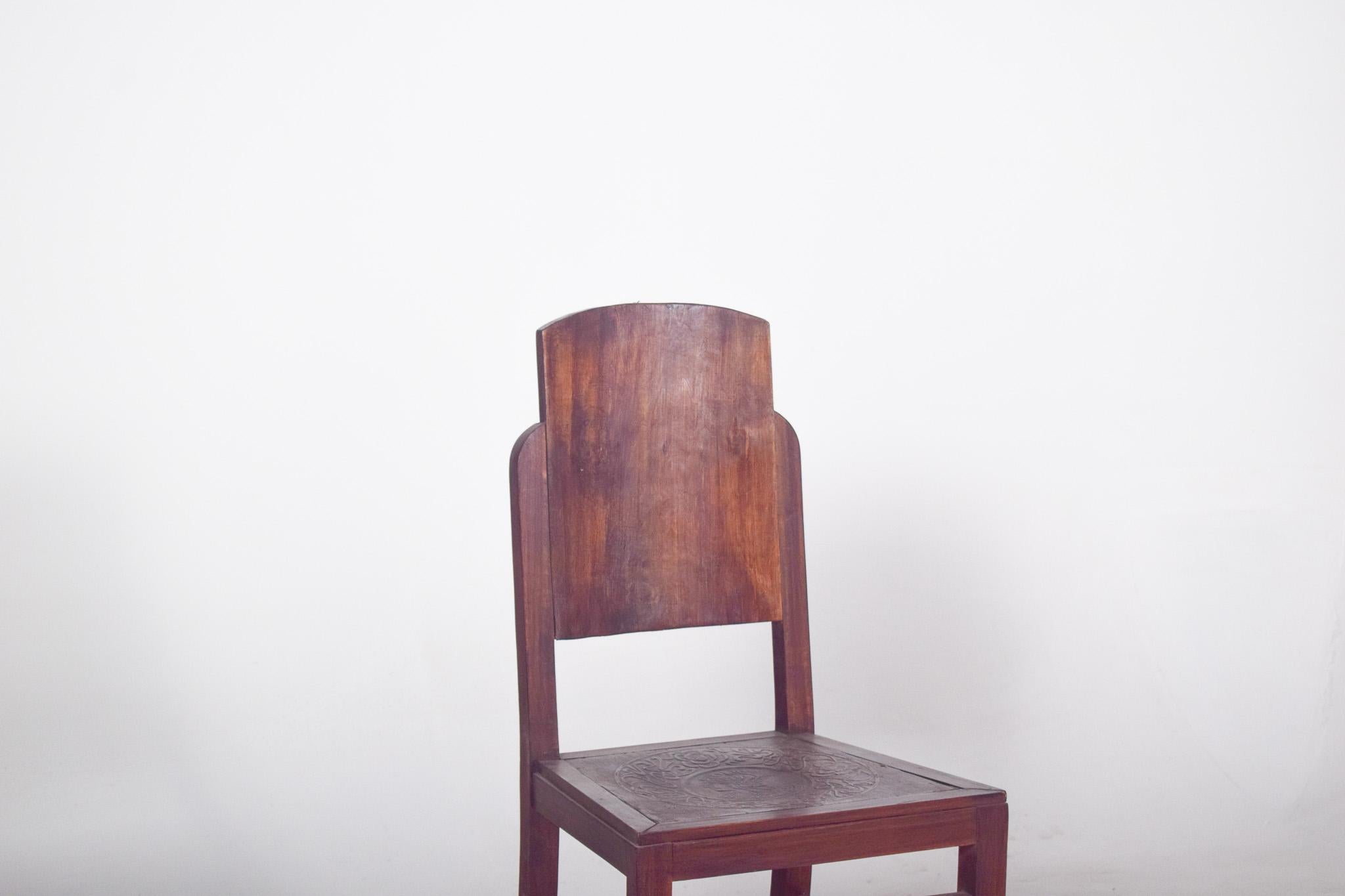 Chaise avec assise en cuir gaufré. D'un design sobre et robuste, avec des lignes droites et un haut dossier en bois massif légèrement arqué en haut, il offre un soutien ferme au dos. Le dossier est continu, sans fuites ni détails, ce qui confère à
