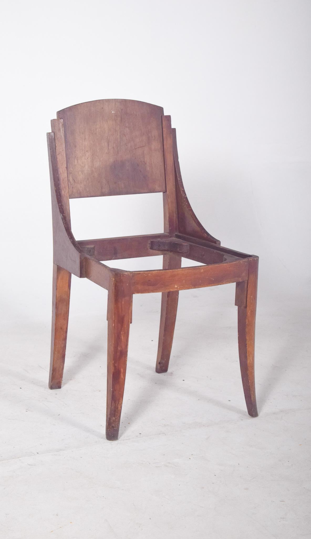 Chaise à dossier incurvé de style déco. Un design saisissant, avec un dossier en bois, incurvé en haut et une structure latérale qui descend en biais jusqu'à la base de l'assise, formant un ensemble sculptural et cohérent. Les lignes géométriques du