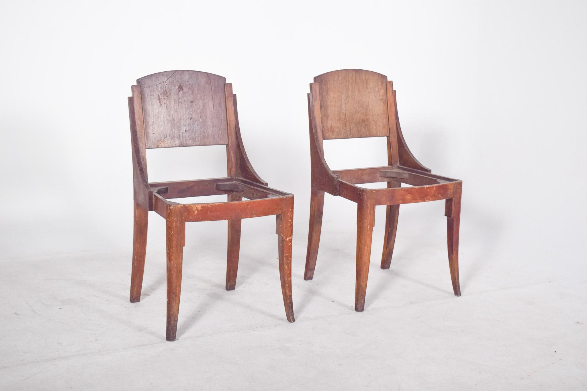 Paire de chaises à dossier incurvé de style déco. D'un design saisissant, avec un dossier en bois, incurvé en haut et une structure latérale qui descend en biais jusqu'à la base de l'assise, formant un ensemble sculptural et cohérent. Les lignes